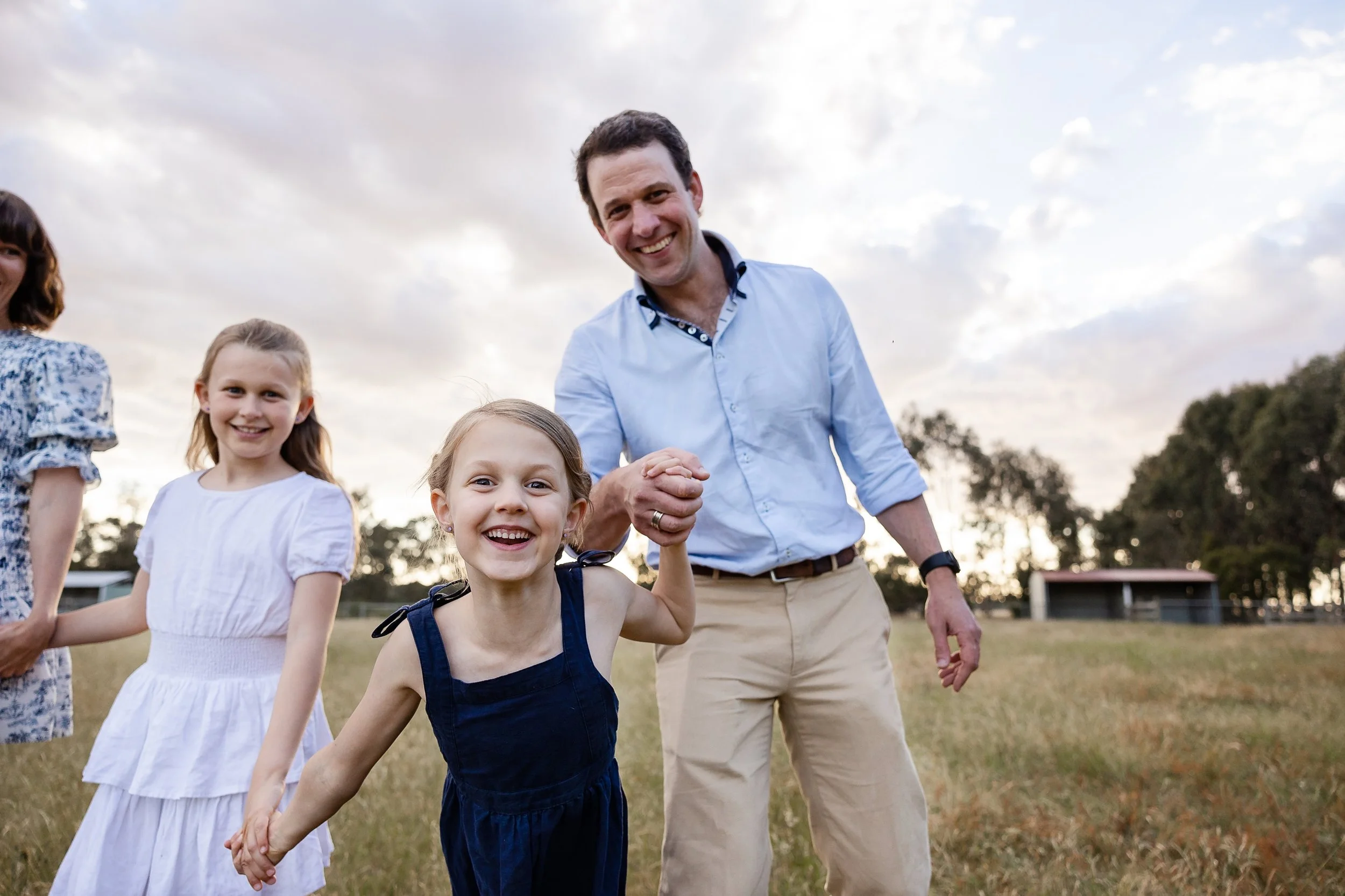 Family laughing and playing on farm