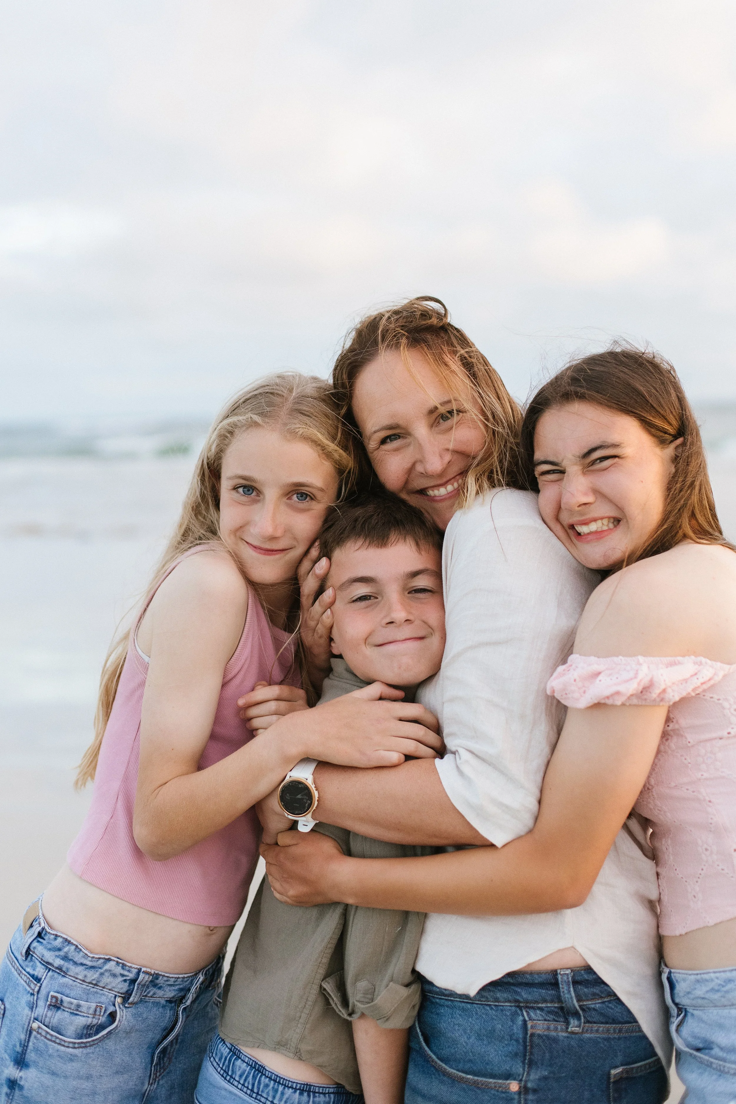 Mum hugging her three teenage children