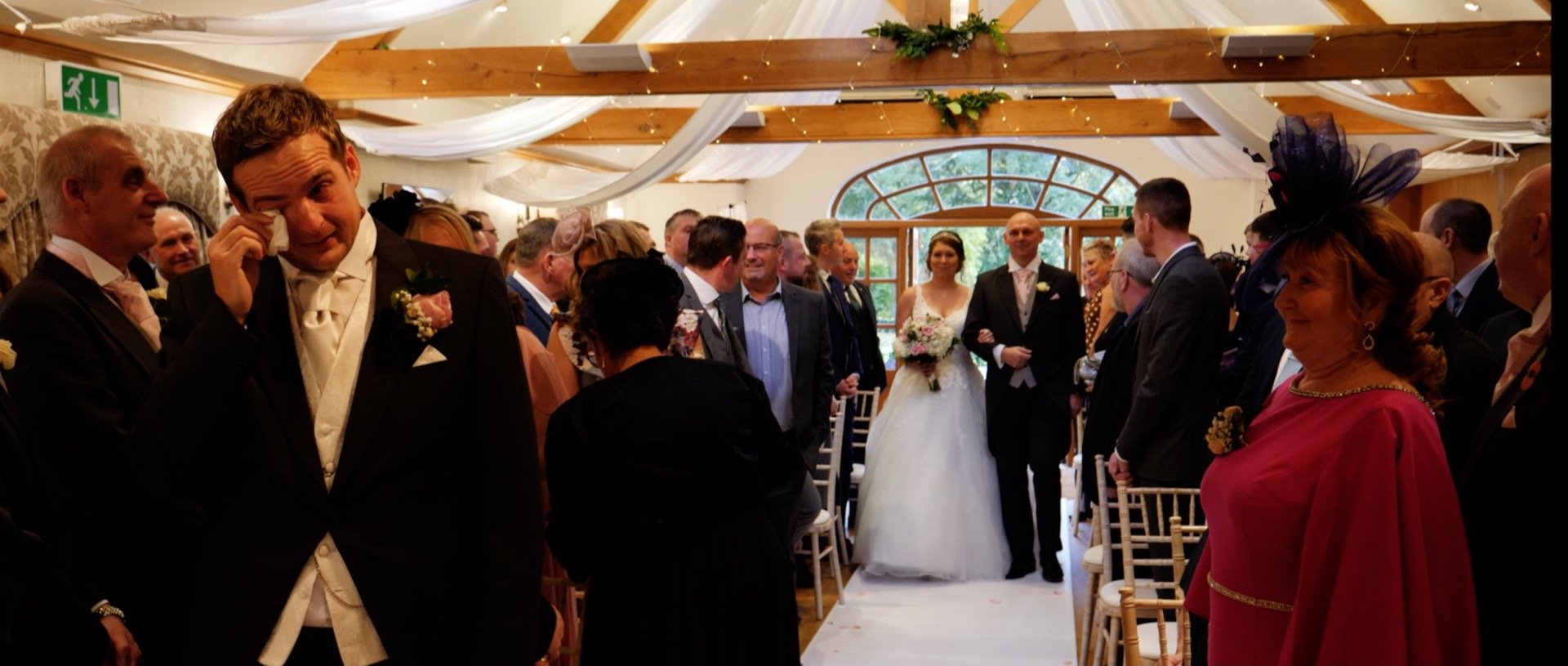 Tears from the groom as bride walks down the asile wedding video Essex.jpg