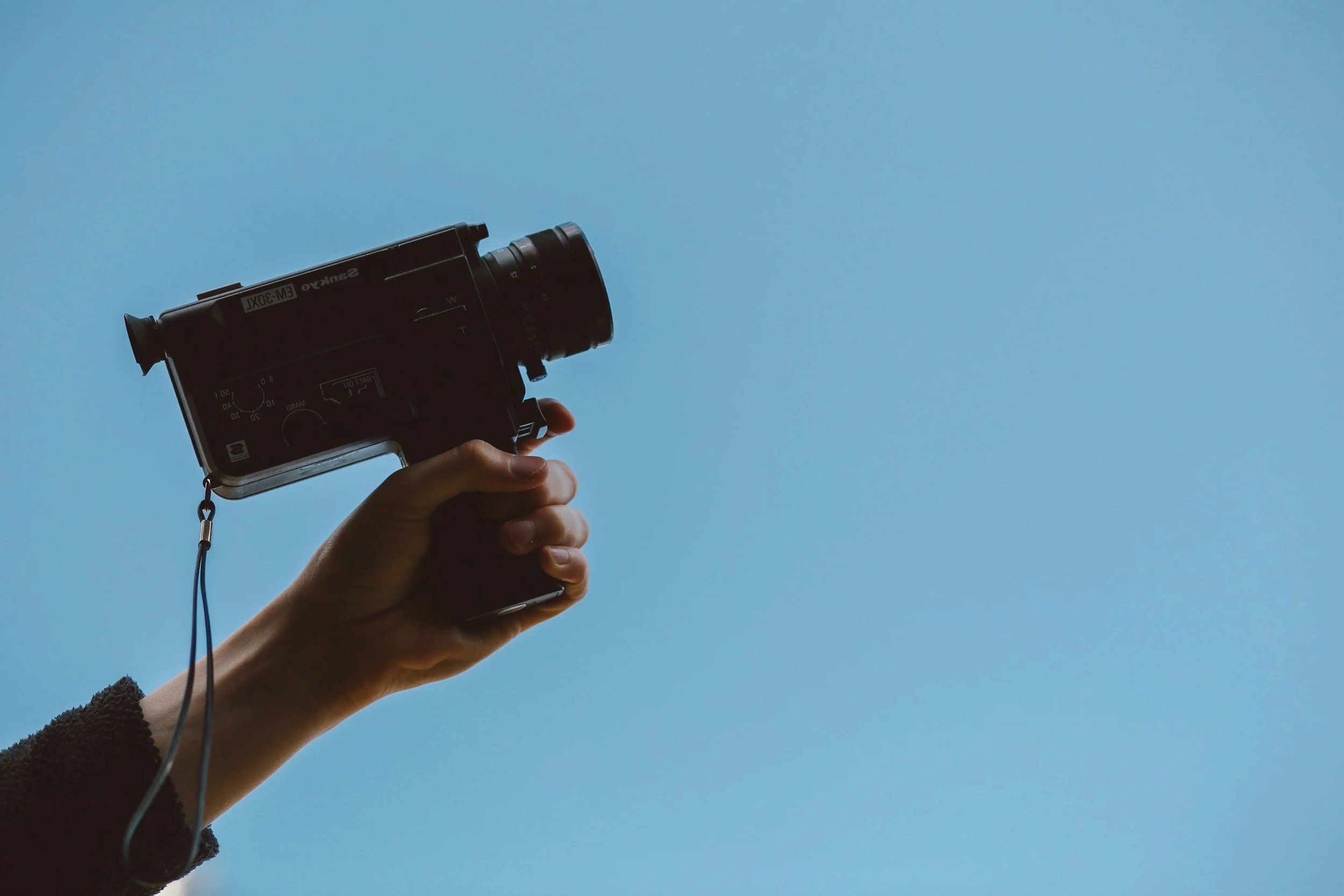 Filmmaker holding a vintage camera representing creative video production in Essex