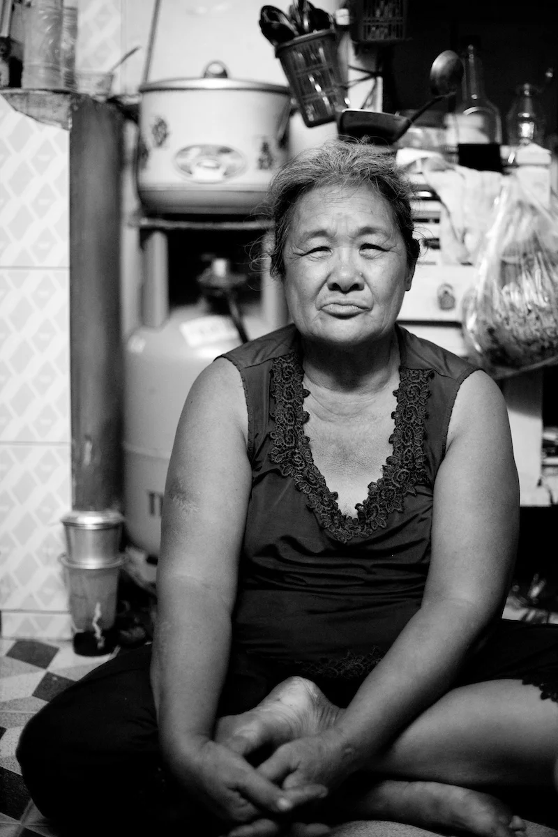 Hoang Thi Dao, 65 years old, Ho Chi Minh City, Vietnam. Dao earns her living since more than 20 years by picking through the garbage in the cities Go Vap district and selling everything that is possible to recycle. With this she makes around 20.000 VND (around 1 USD) per night. She takes care of her two granddaughters Truc and Cuc (12 years old).