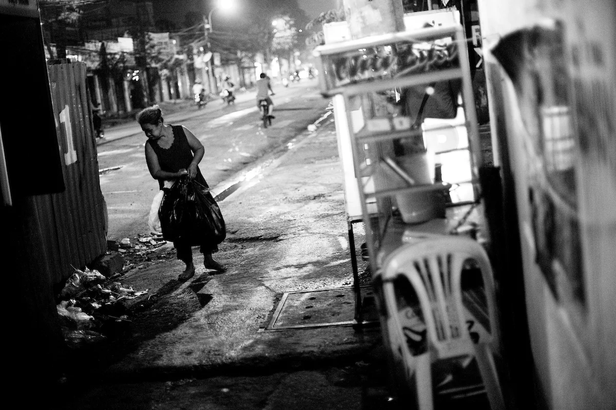 Hoang Thi Dao, 65 years old, Ho Chi Minh City, Vietnam. Dao earns her living since more than 20 years by picking through the garbage in the cities Go Vap district and selling everything that is possible to recycle. With this she makes around 20.000 VND (around 1 USD) per night. She takes care of her two granddaughters Truc and Cuc (12 years old).