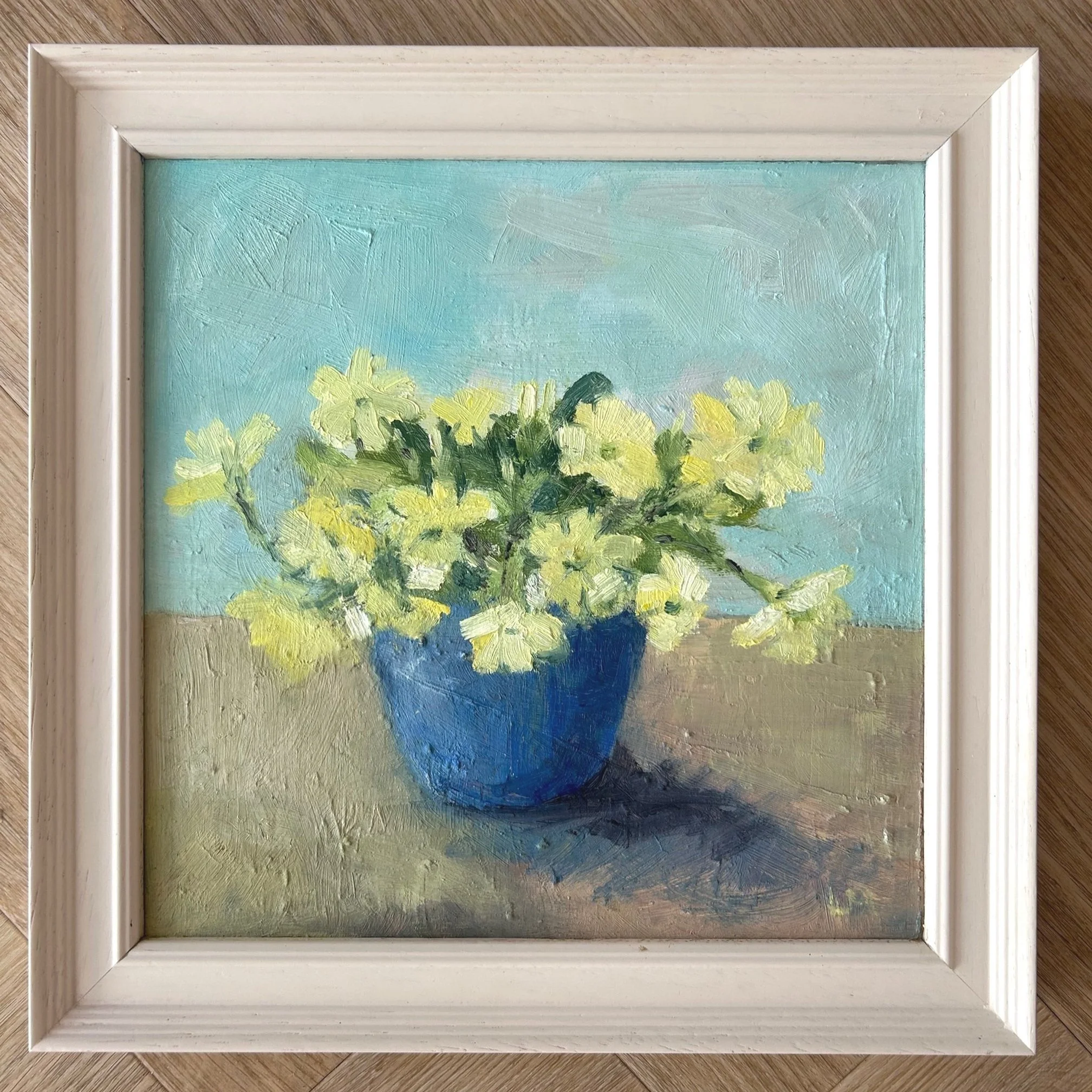 Yellow primroses in a blue vase by Louise Man