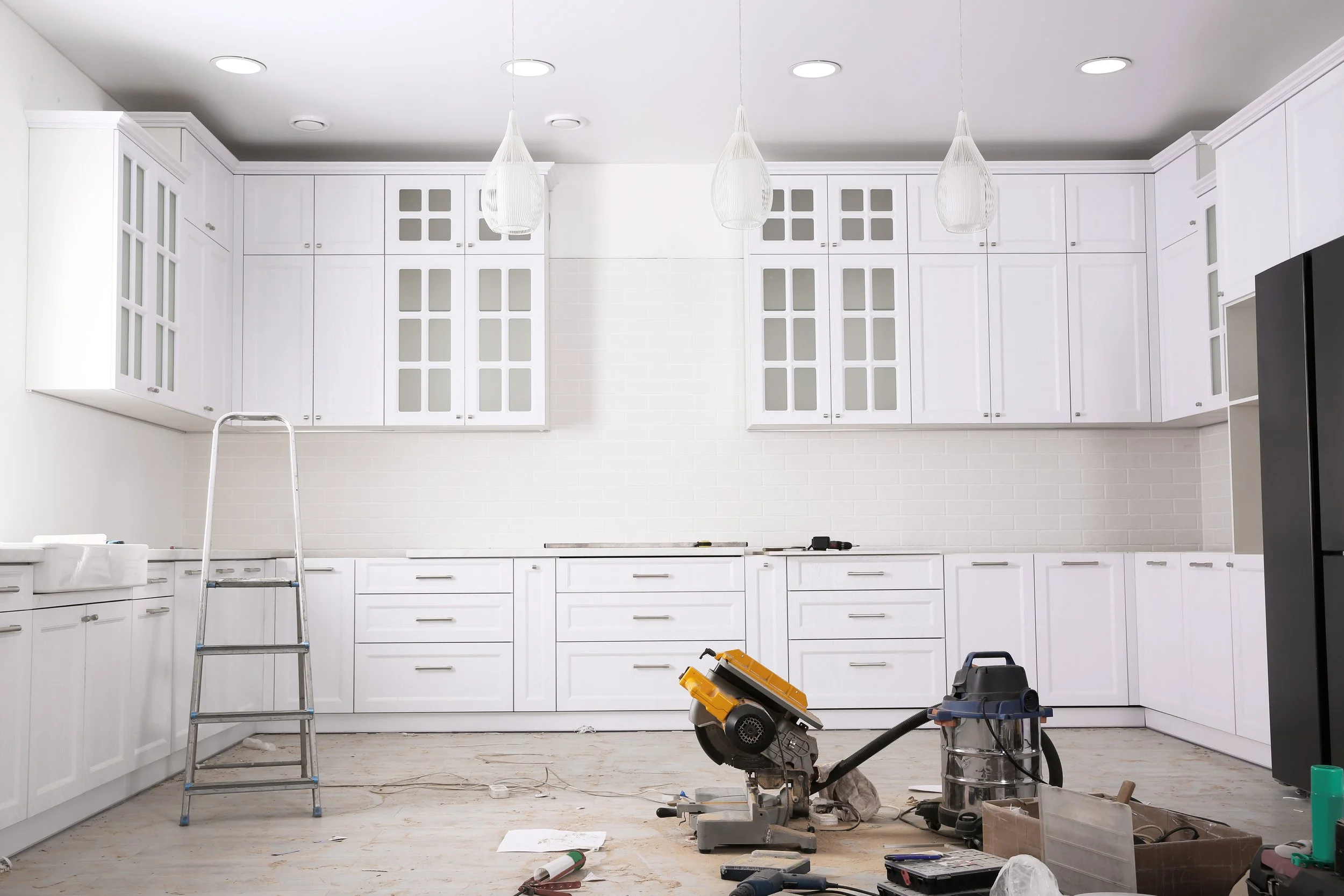 Image alt text: a large kitchen space undergoing renovation, featuring a step ladder and various equipment.