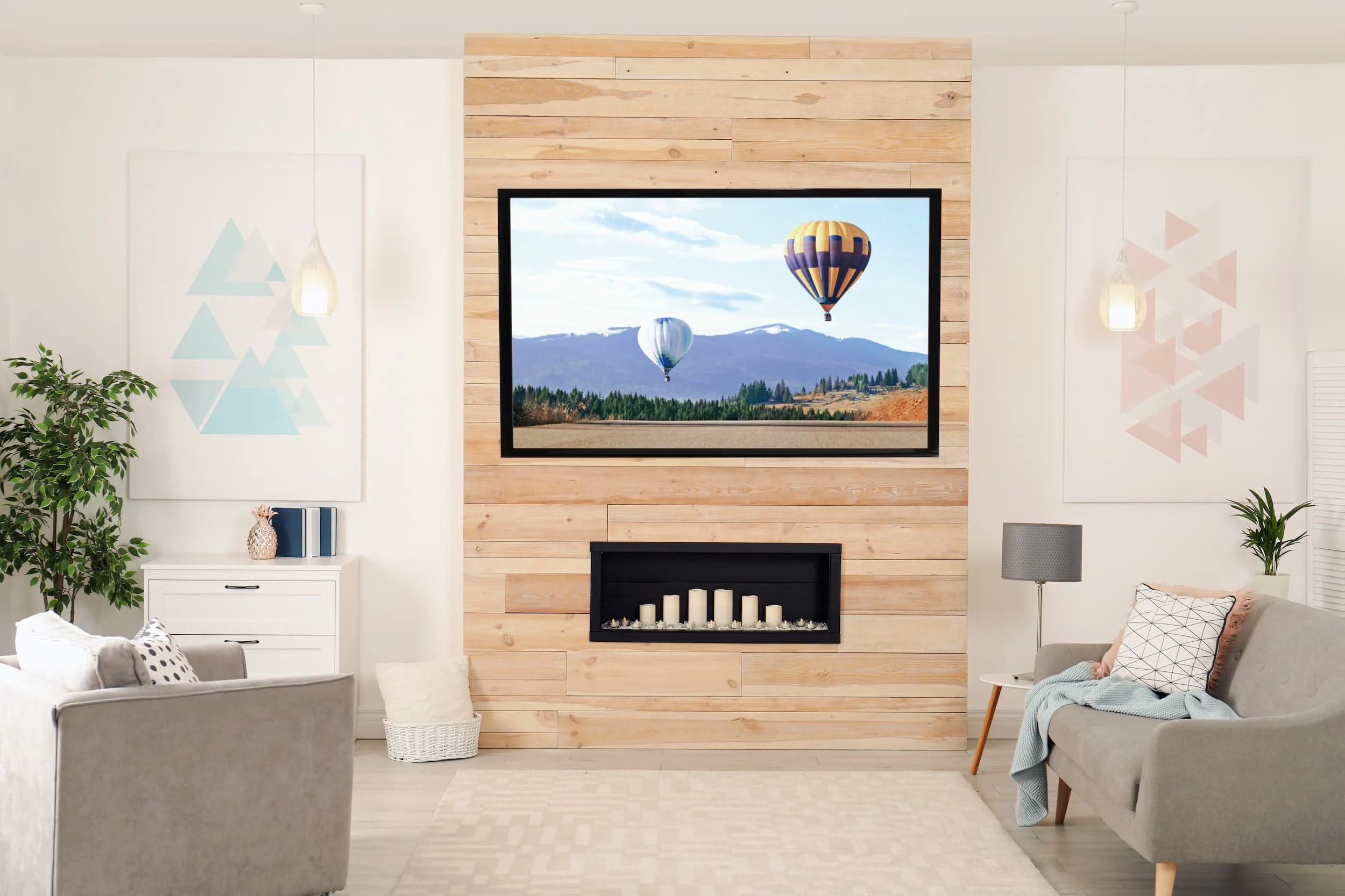 A light, airy lounge centred around a light wood media wall featuring a TV and candle arch fireplace.