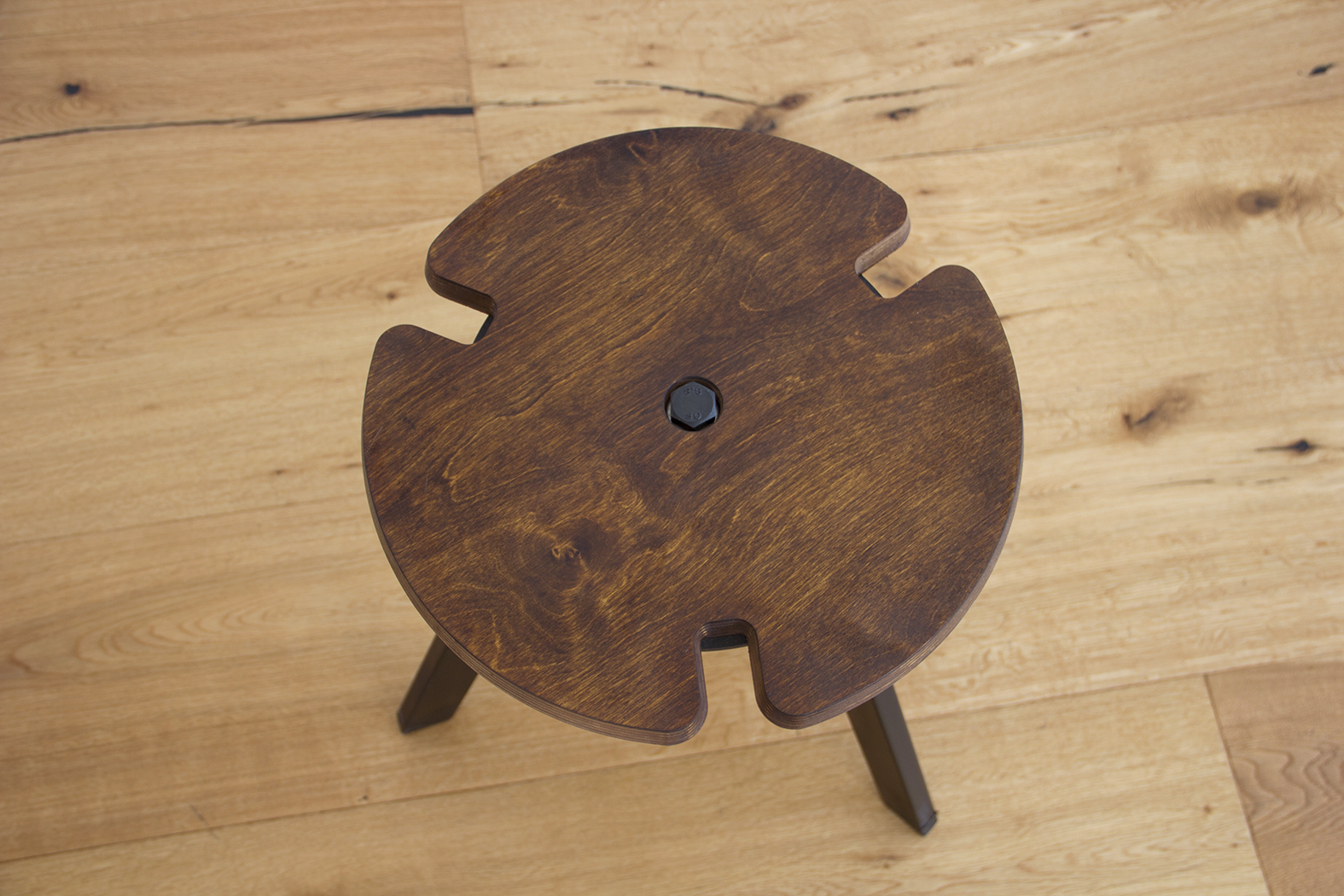 Close-up detail of the seat edge, showing how the rebates are cut into the wood to guide the legs of the stool above for secure stacking.