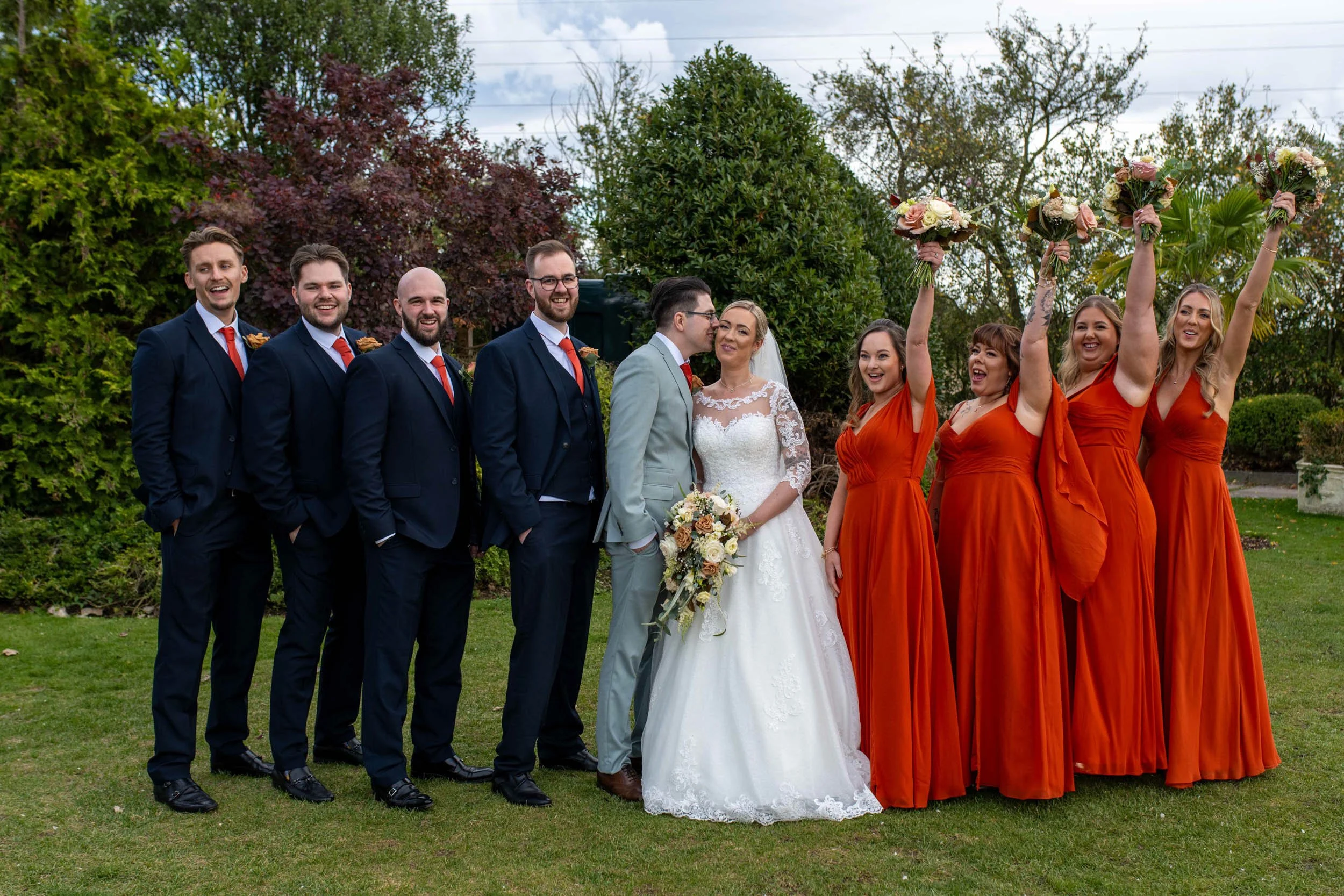 Friern Manor wedding bridesmaids and groomsmen celebrating a kiss from the bride and groom