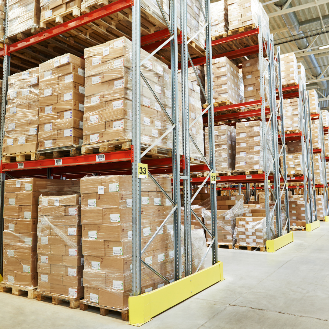 A warehouse is filled with products and has pallets filled with products and plastic packaging.
