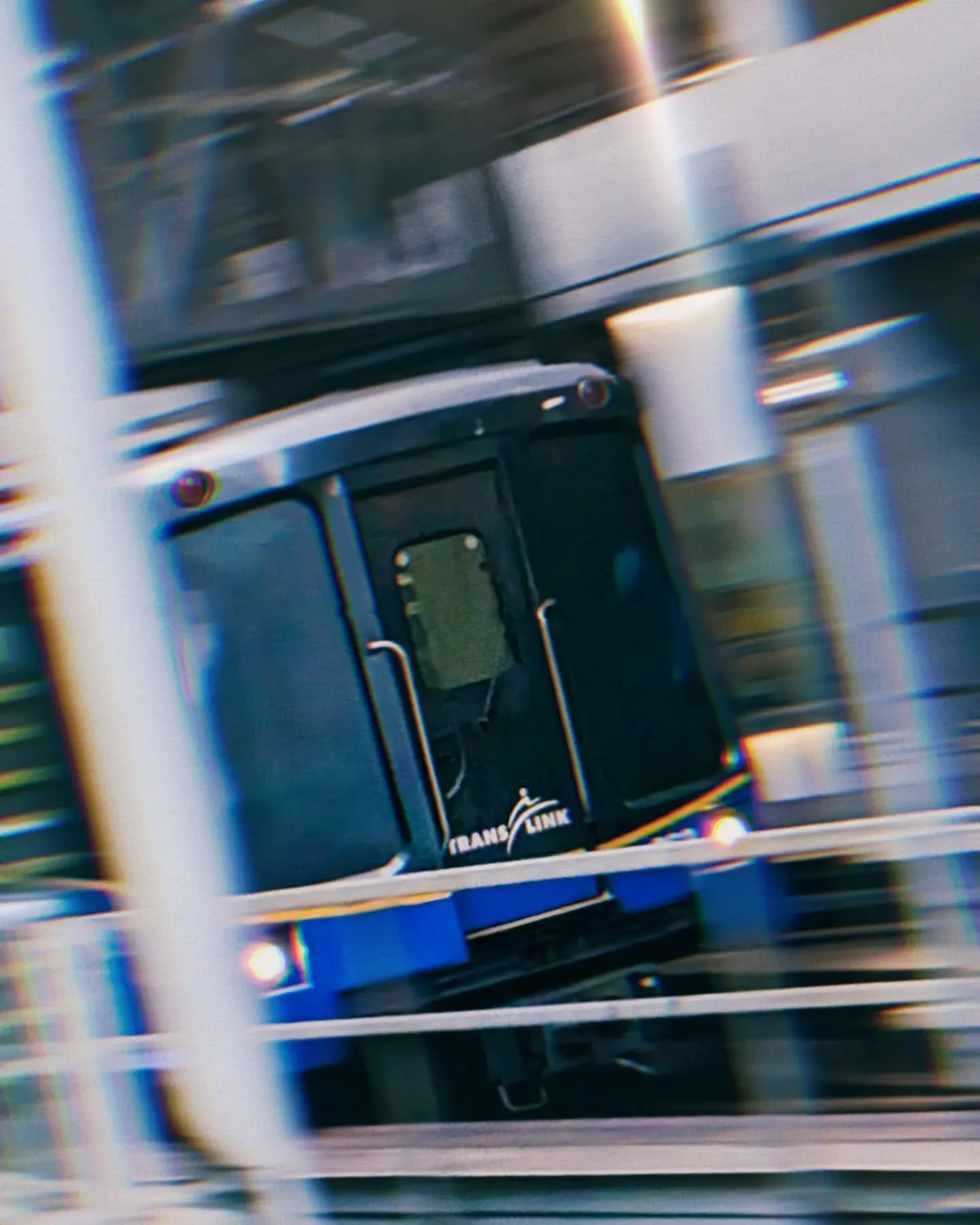 Close-up of a 3D printer's extruder with a reel of filament in the background.