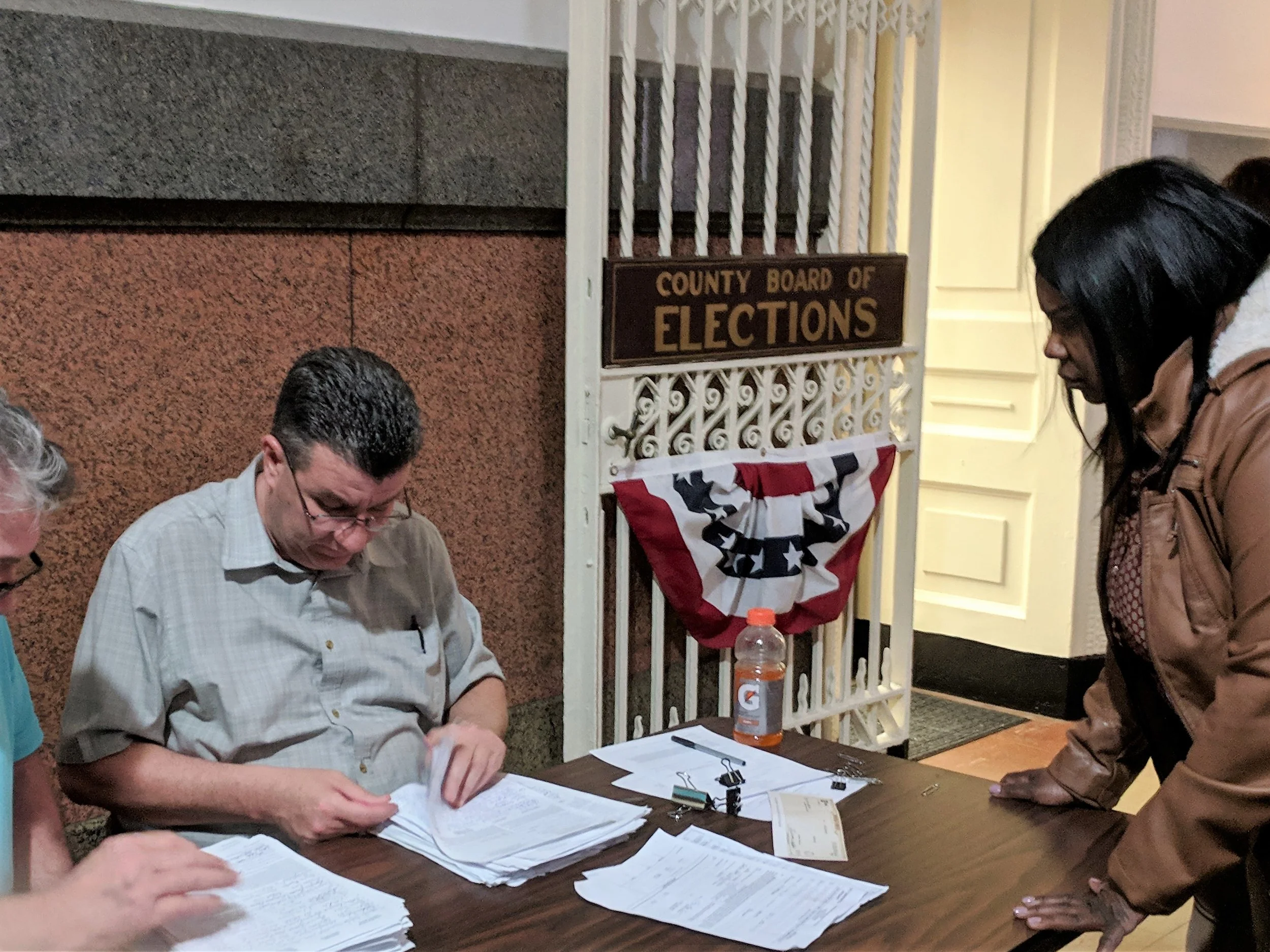 Carla Cain (right) submits petitions with almost 4,100 signatures at the County Board of Elections