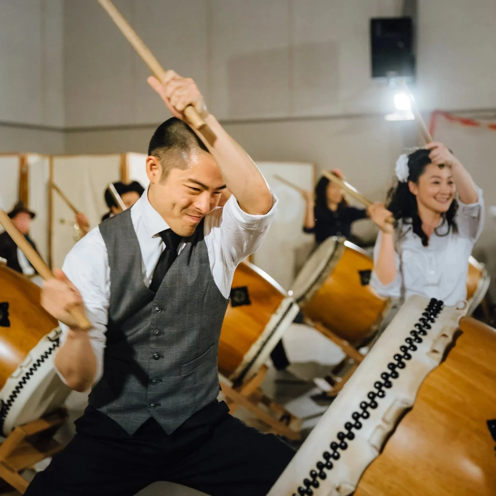 Two swing dance era people perform taiko