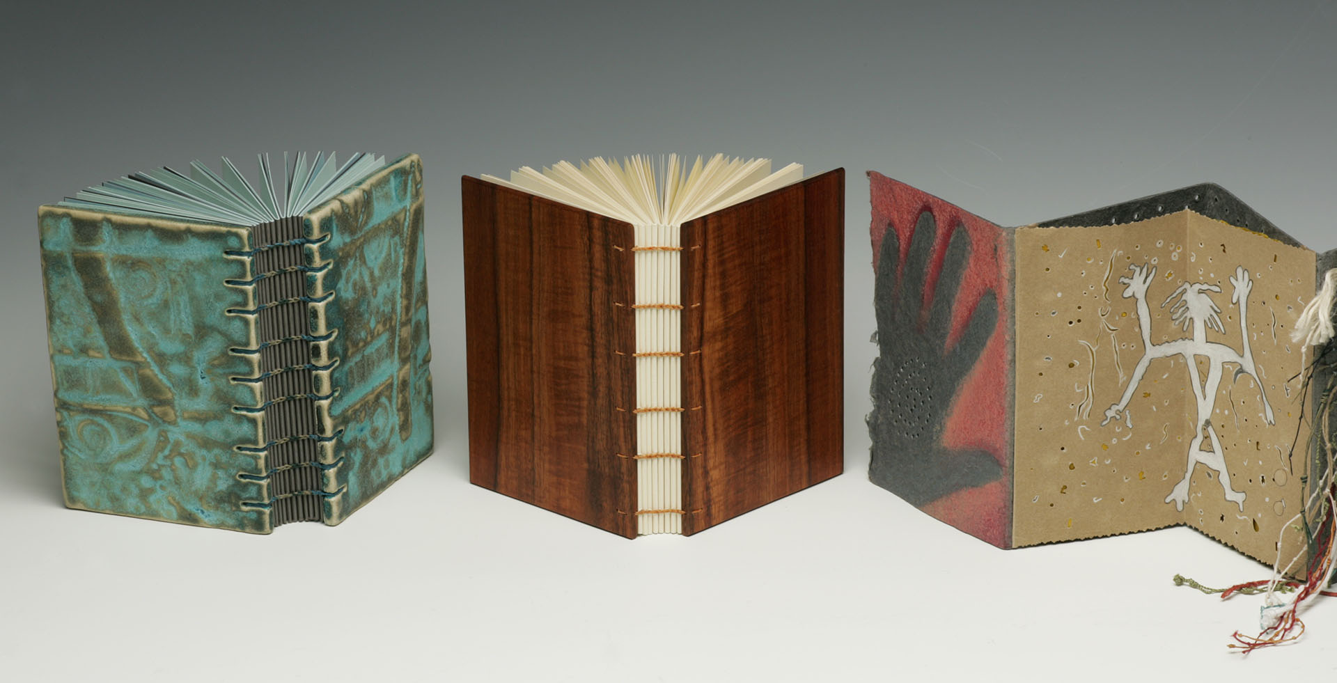 Two Coptic-sewn bindings and accordion pages representing cave paintings and petroglyphs