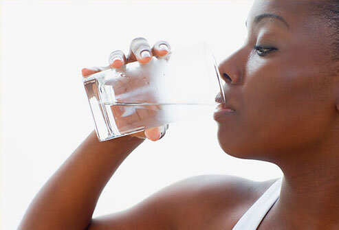Black woman drinking water from a glass