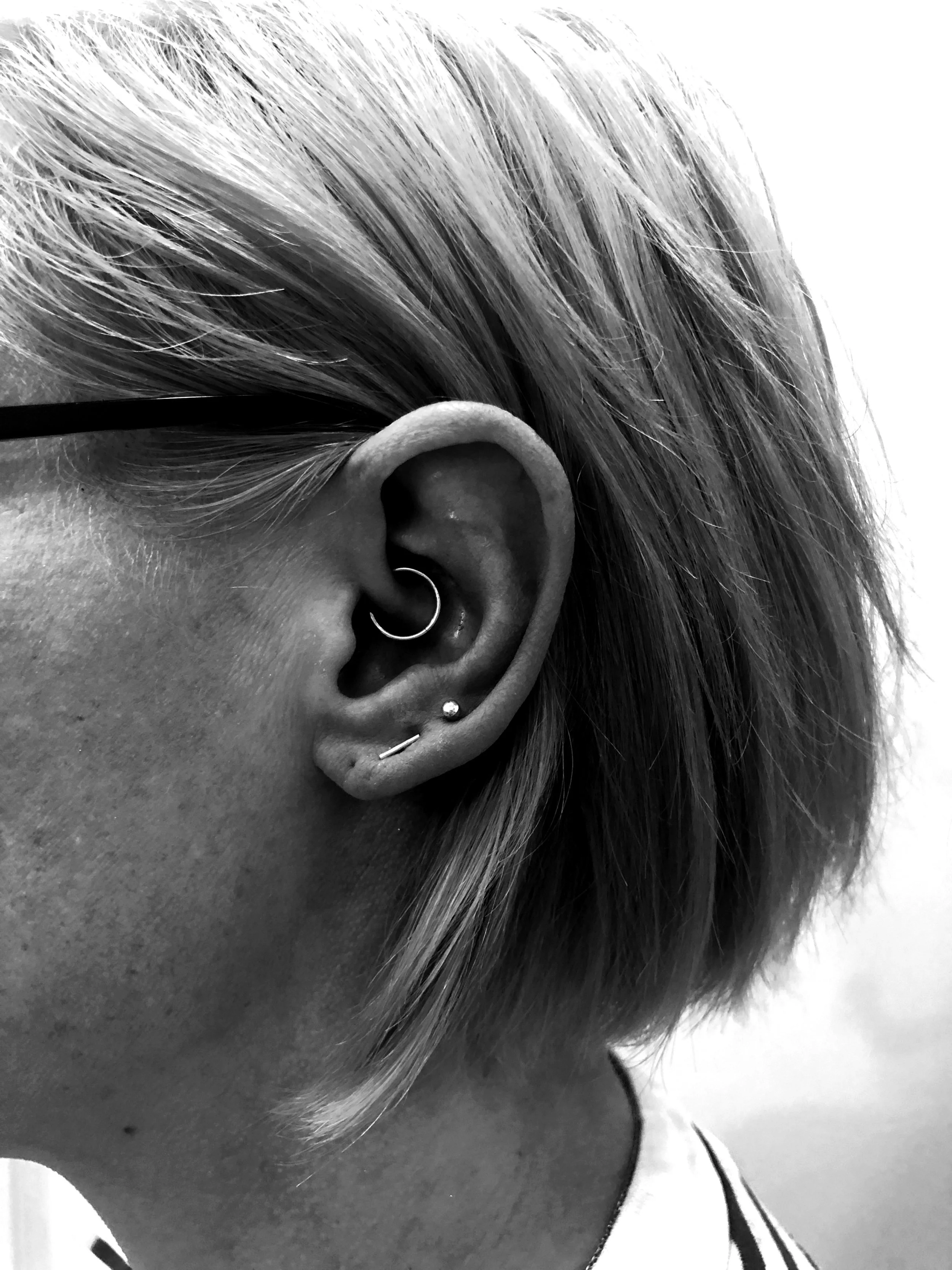 Beautiful Daith piercing alongside existing lobe piercings