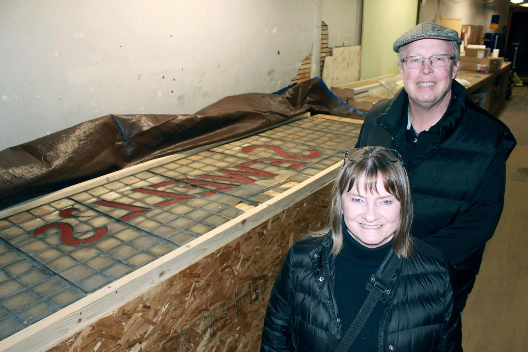 Lee Whitney, administrative coordinator for the Butte Citizens for Preservation and Revitalization, poses for a picture with Joe Floreen, building owner, next to the transom prismatic fixture that has adorned the Sewell's building at 221 E. Park St. for over 100 years. (Photo by Annie Pentilla, The Montana Standard)