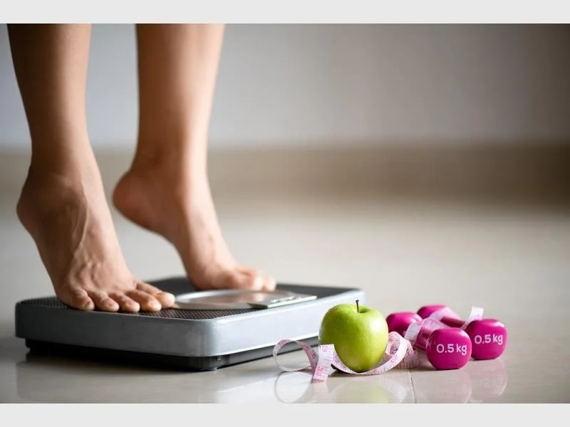 image of women on scale evaluating her weight loss goals