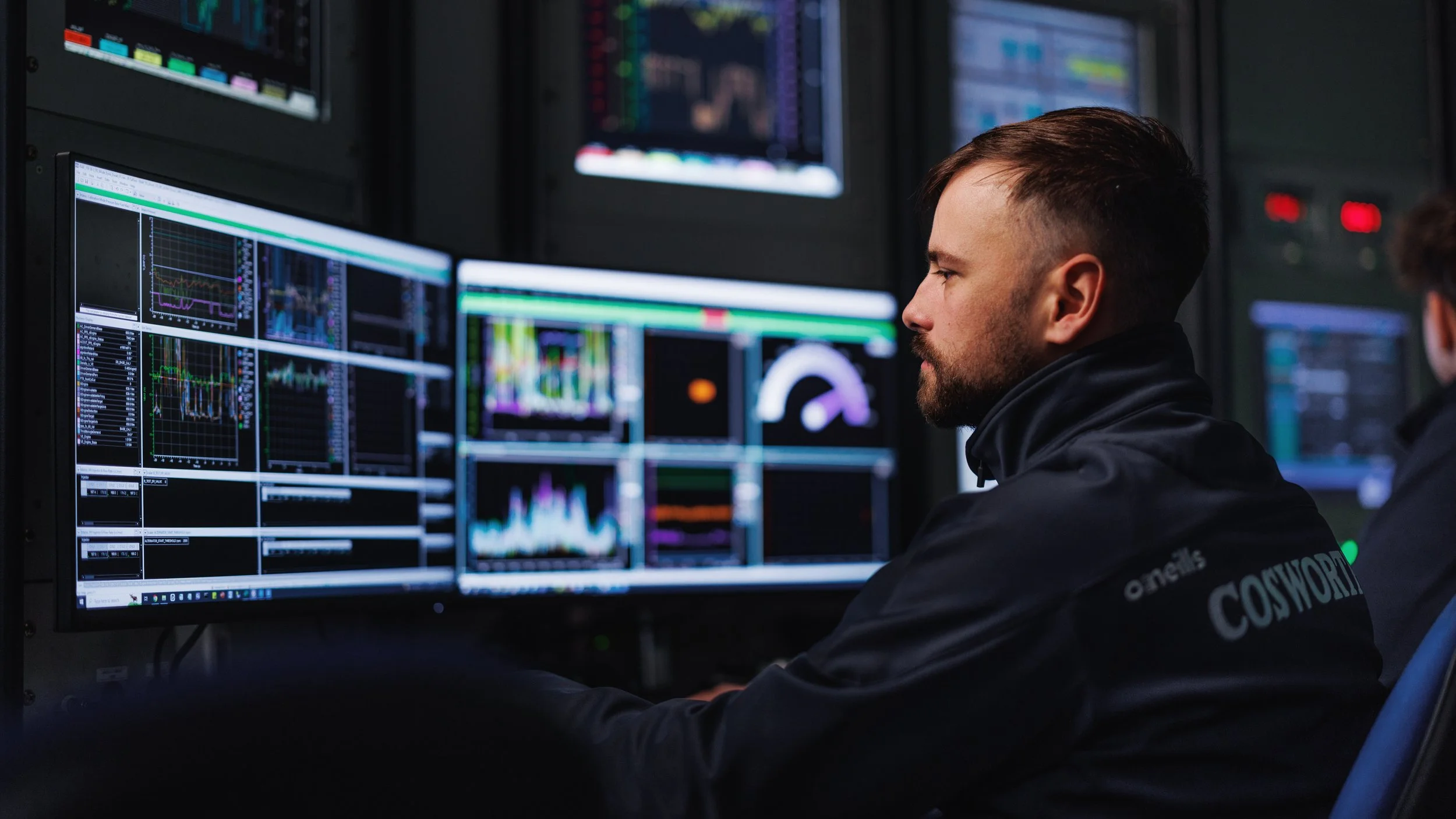 Engineer monitoring engine test data on a bank of screens in a dyno control room | Anthony Mark Saul