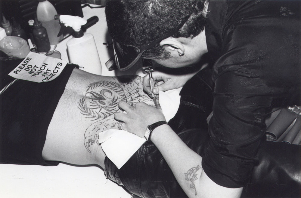  Ruth Marten inking a tattoo at the exhibition opening.