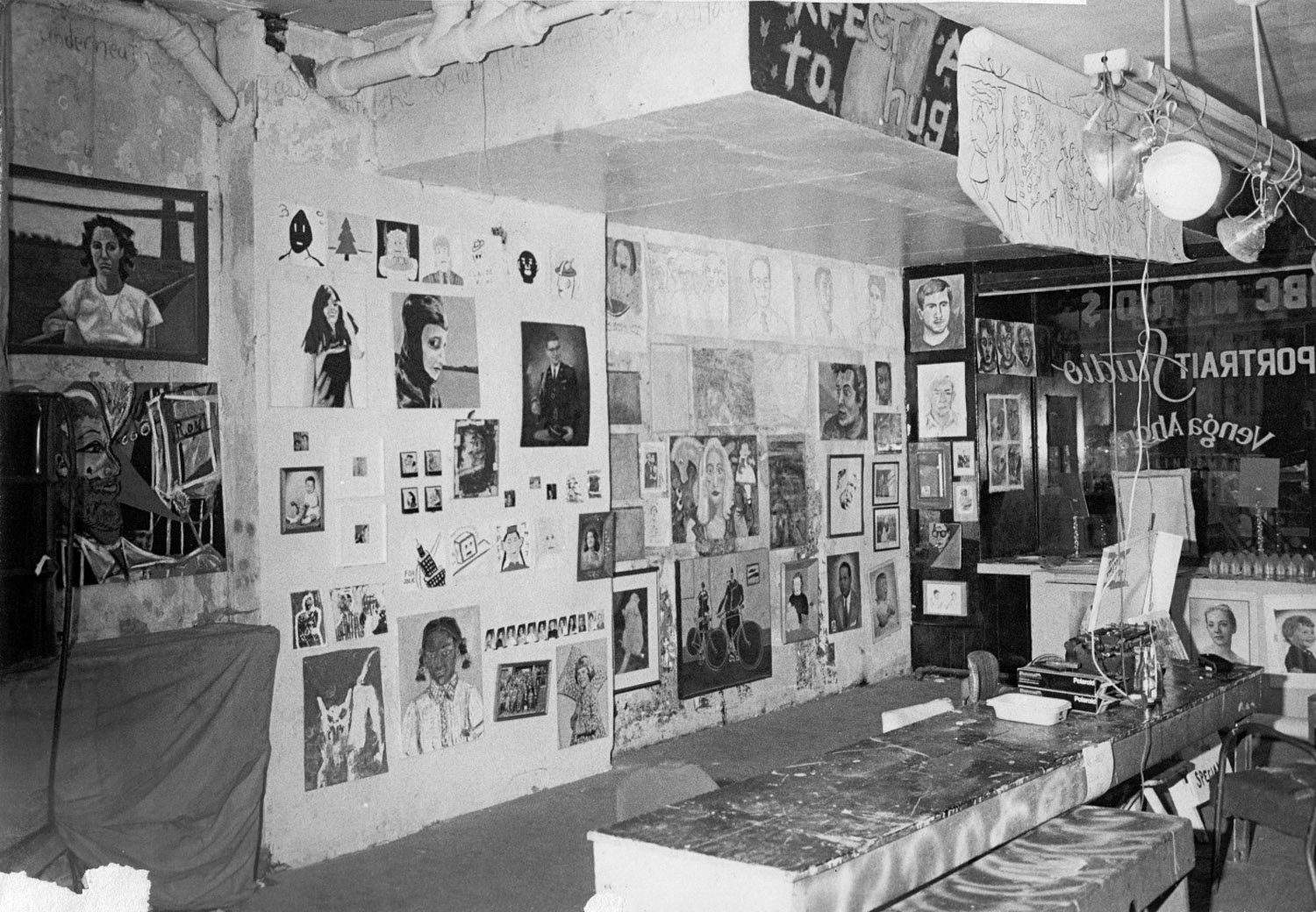 Installation view of the east wall of the gallery during the Portrait Show. Tom Warren mixed photographs from the abandoned photographers' studio next door with artists' work on the walls