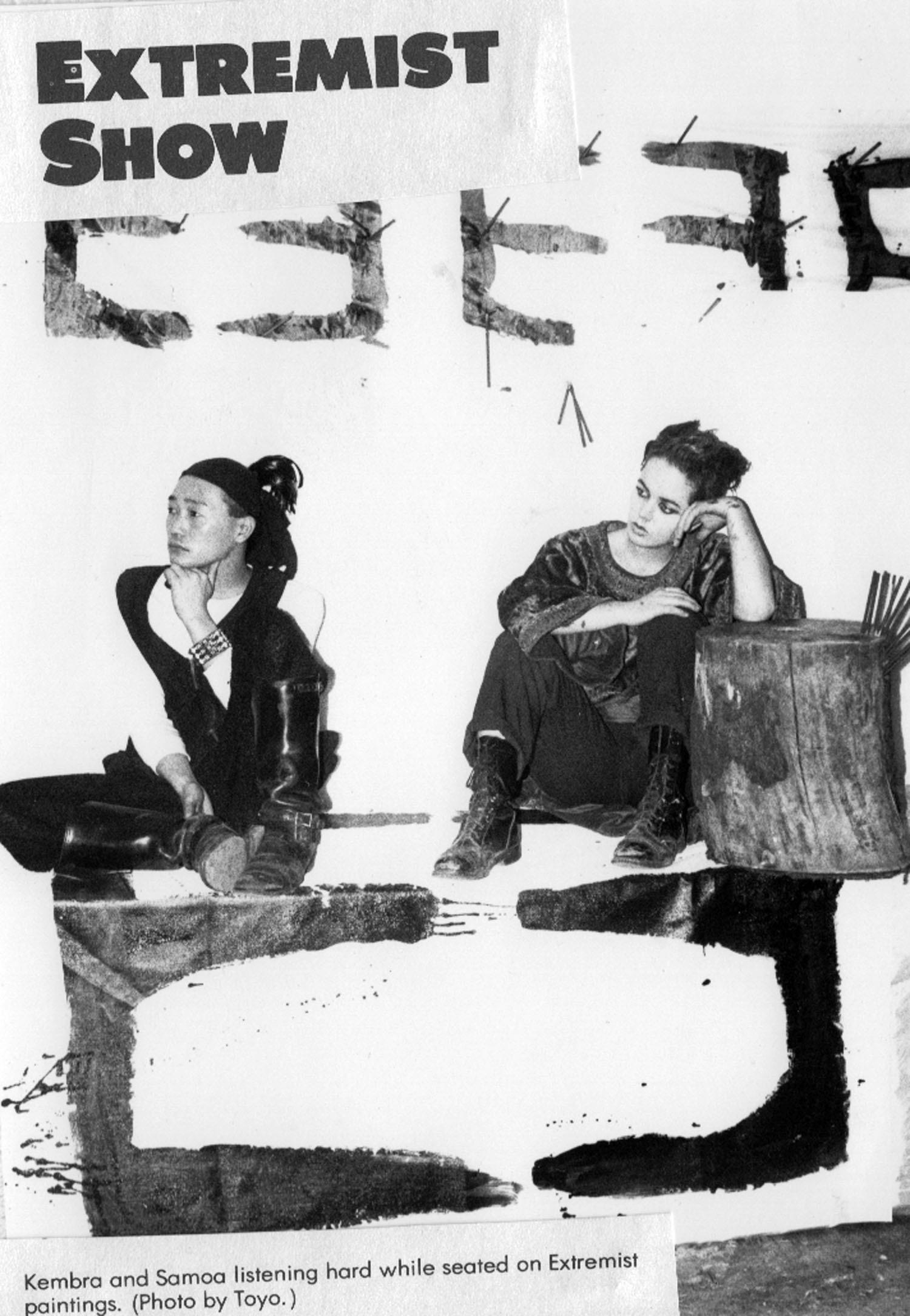 Kembra and Samoa seated on Extremist paintings. Photo by Toyo