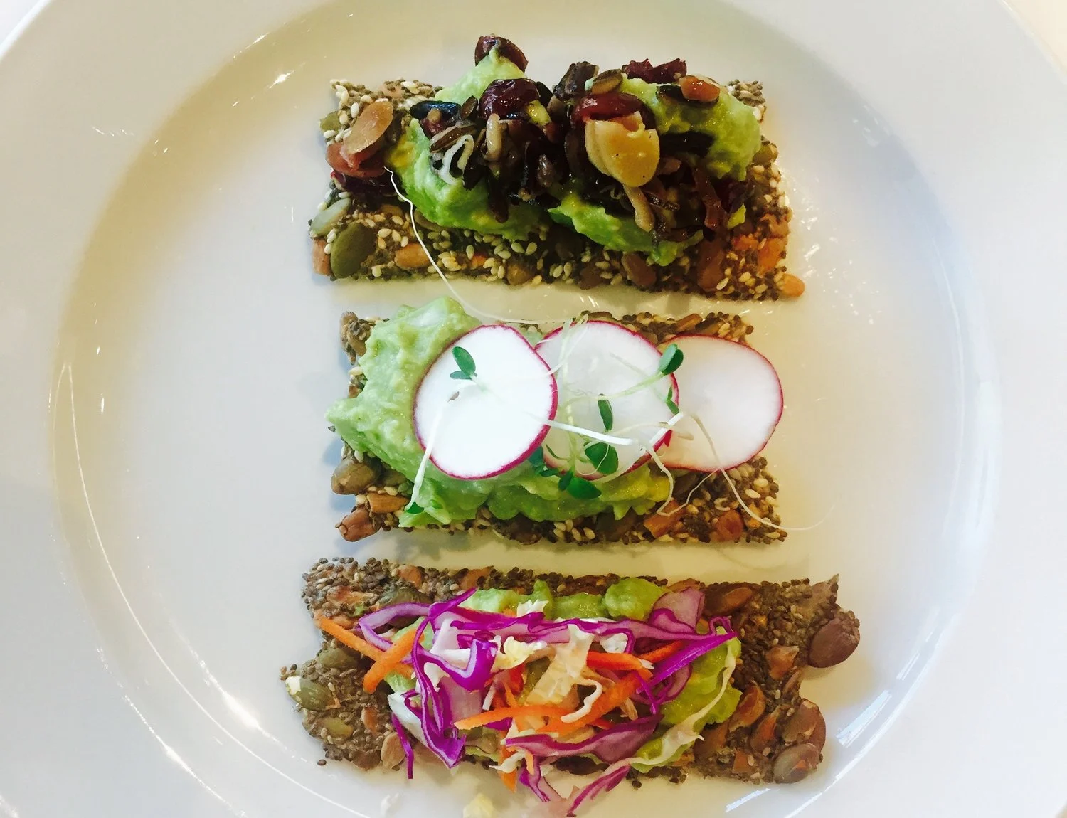 Seeded crackers with avocado spread.