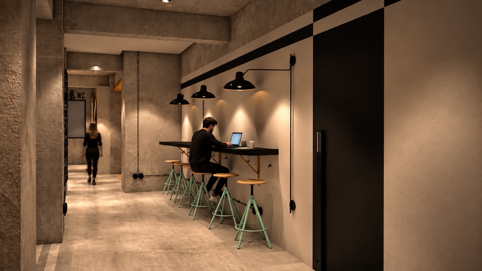 Interior of a modern cafe with a man working on a laptop at a counter with multiple mint green stools, black pendant lights, concrete walls, and a woman walking away in the background.