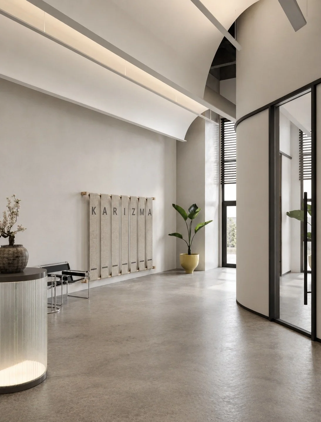 Modern, minimalistic interior with a curved glass wall, potted plant, textile wall art with the name "Karizma," and a vase with white flowers.