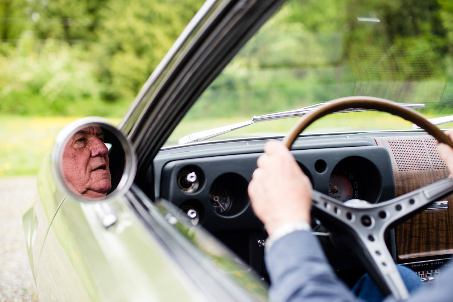 octogenarian man driving vintage car