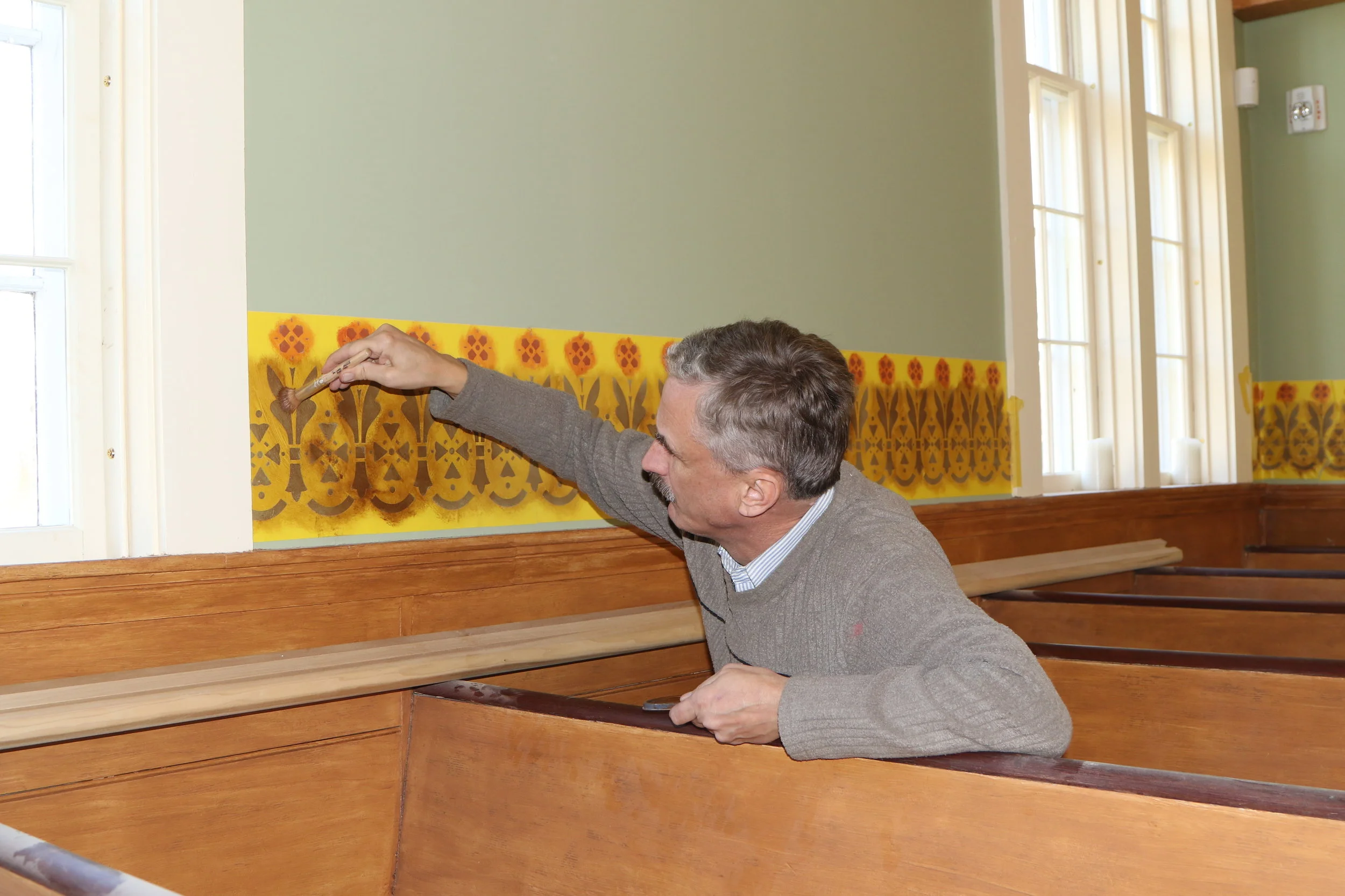 Lars Michelsen working on stenciling the main hall.