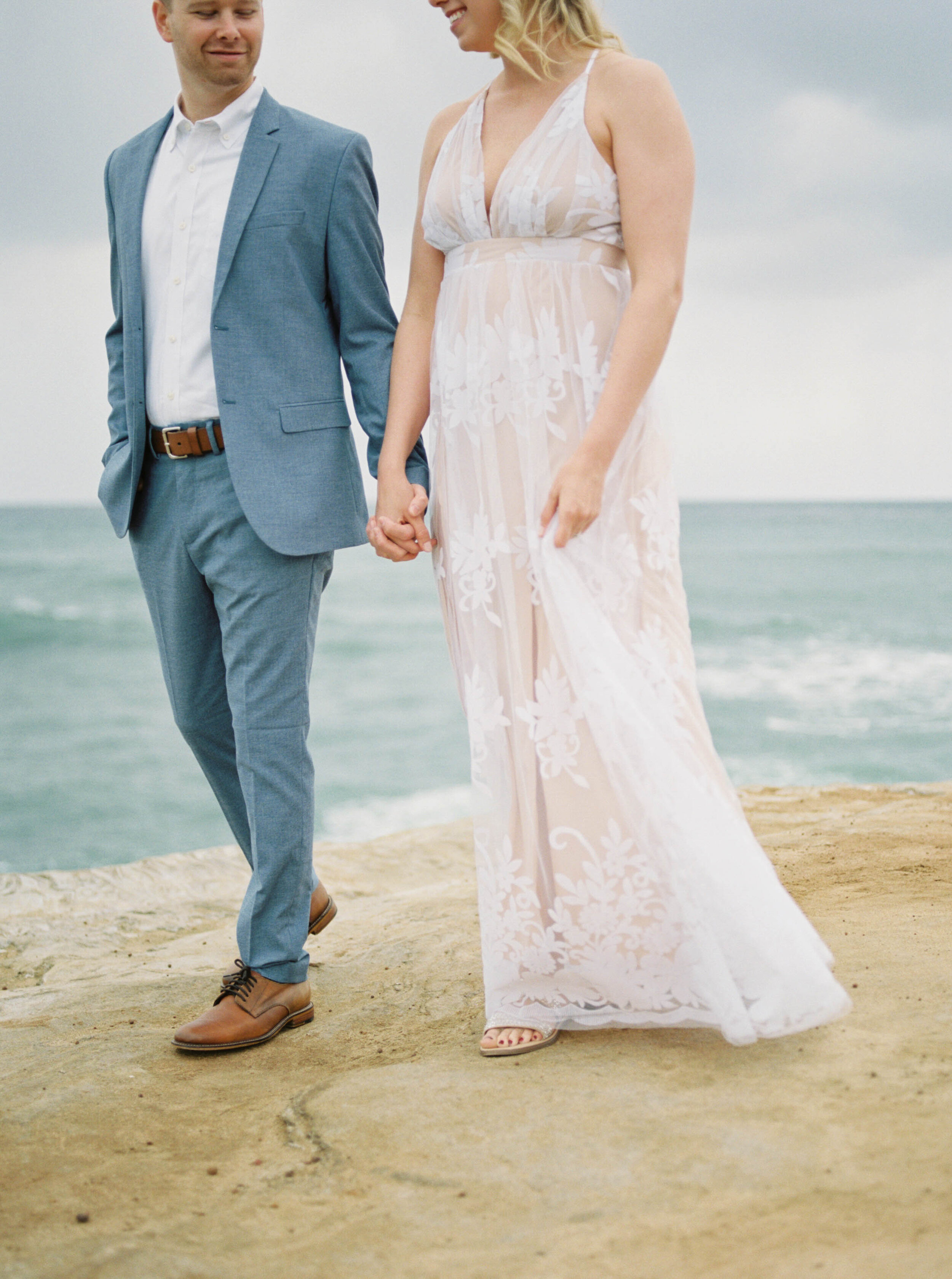 Anniversary wedding session on film at the Sunset Cliffs in San Diego California with stylish white flowy dress and blue suit by the ocean and beach by Liz Andolina Photography