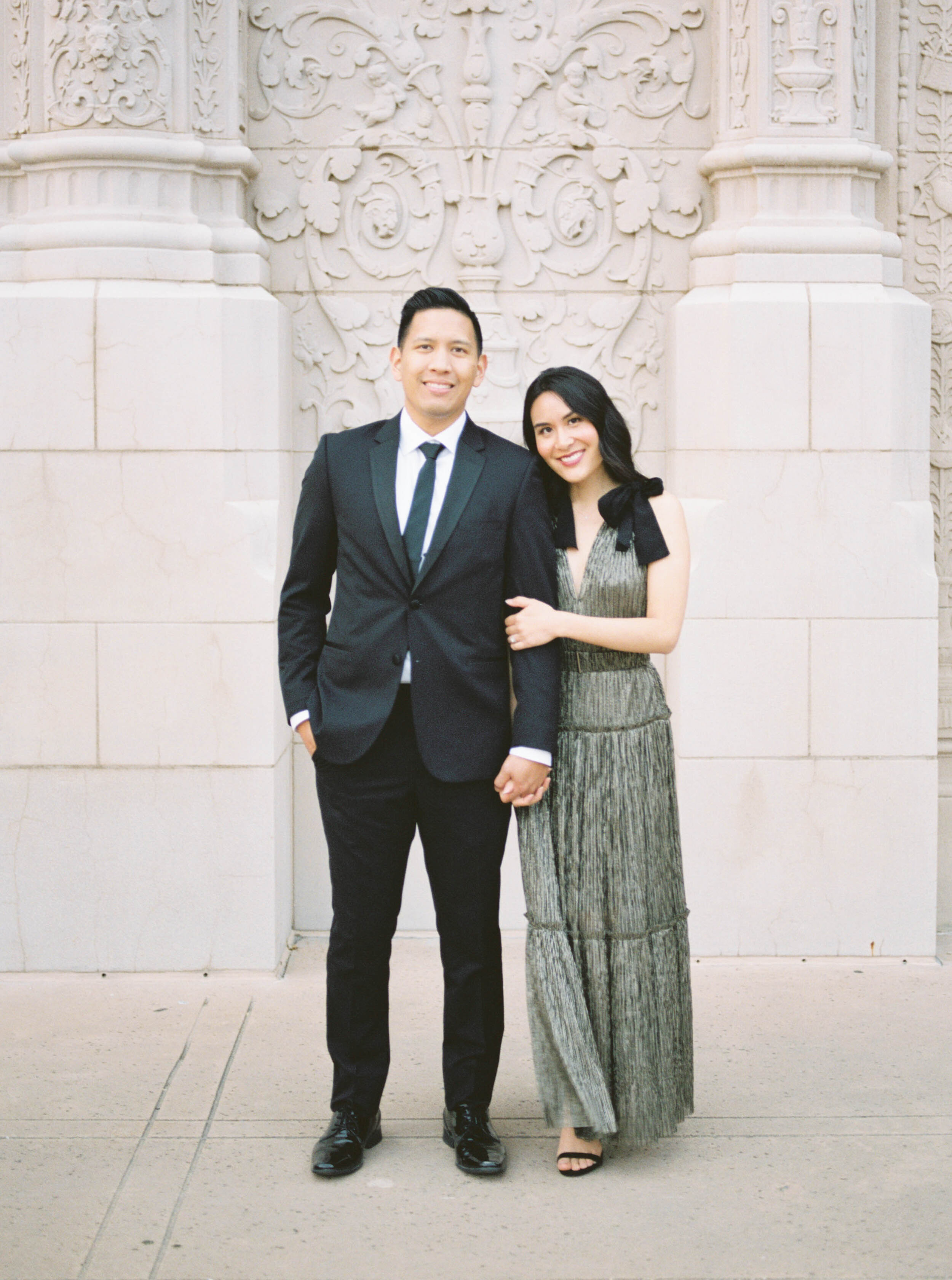 Engagement session on film with stylish gold and black Revolve dress and black suit at Balboa Park in San Diego by Liz Andolina Photography