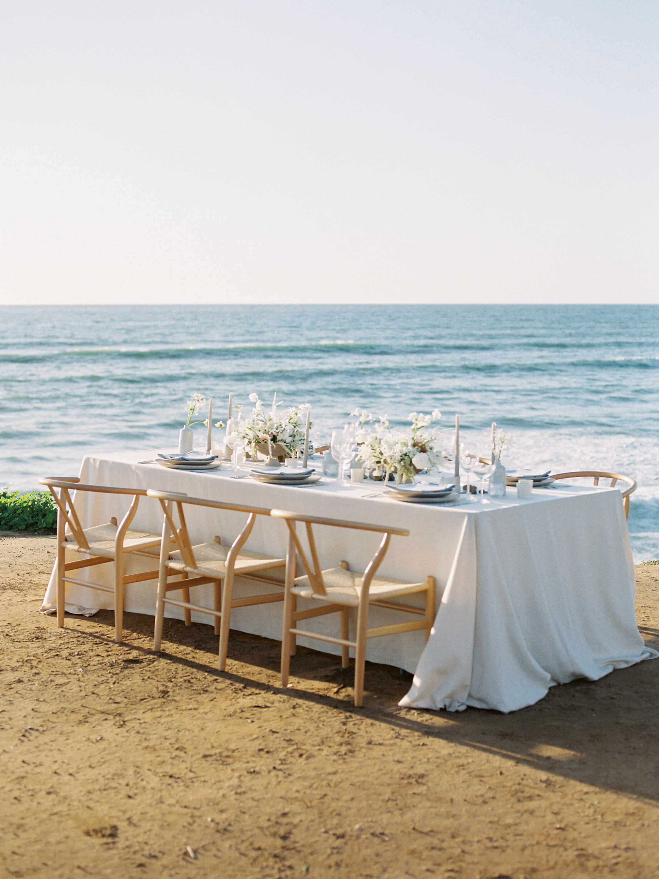 Elegant ocean inspired wedding with blue wedding dress and white tux on film at the Sunset Cliffs in San Diego California by Liz Andolina Photography
