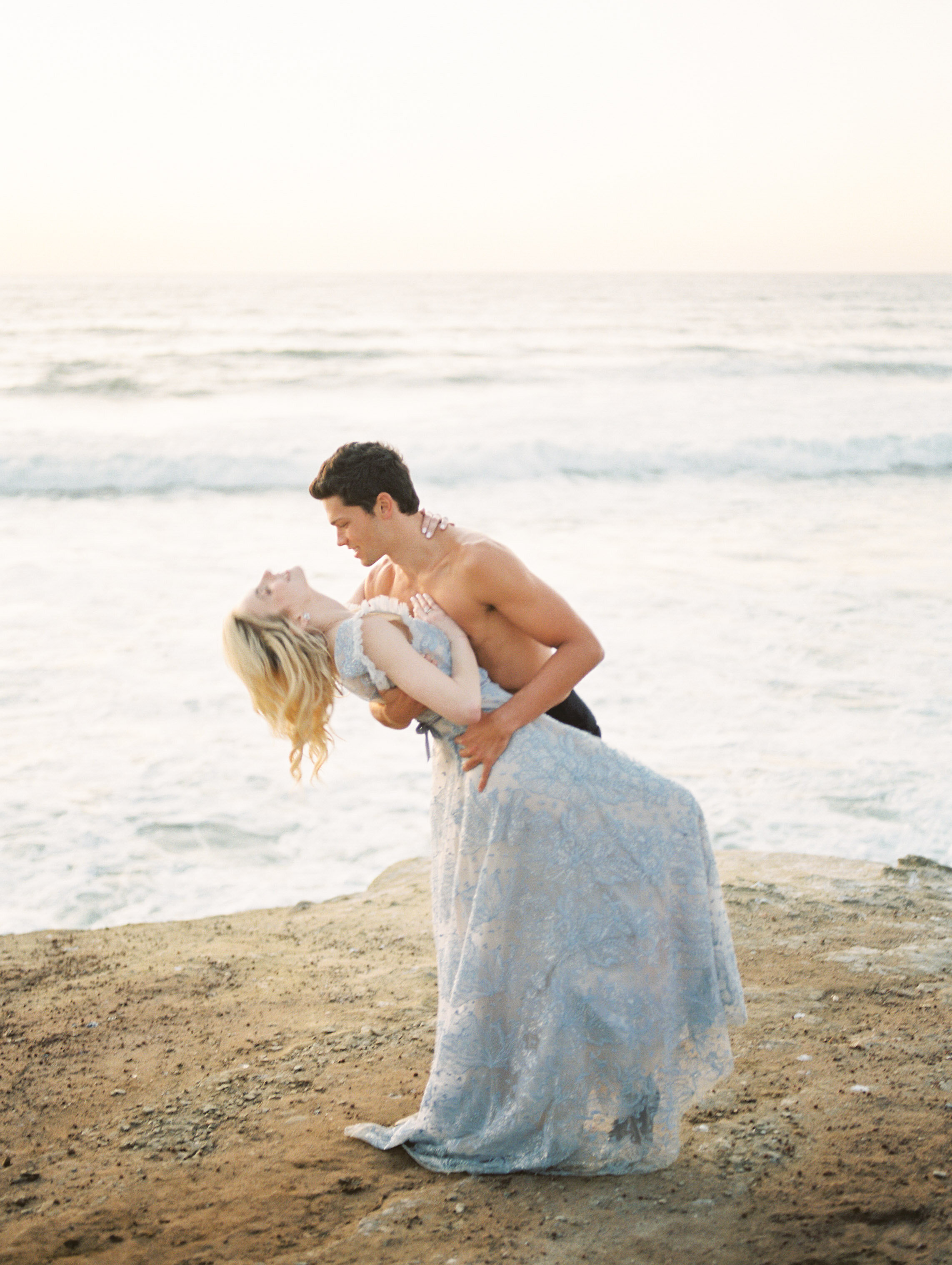 Elegant ocean inspired wedding with blue wedding dress and white tux on film at the Sunset Cliffs in San Diego California by Liz Andolina Photography