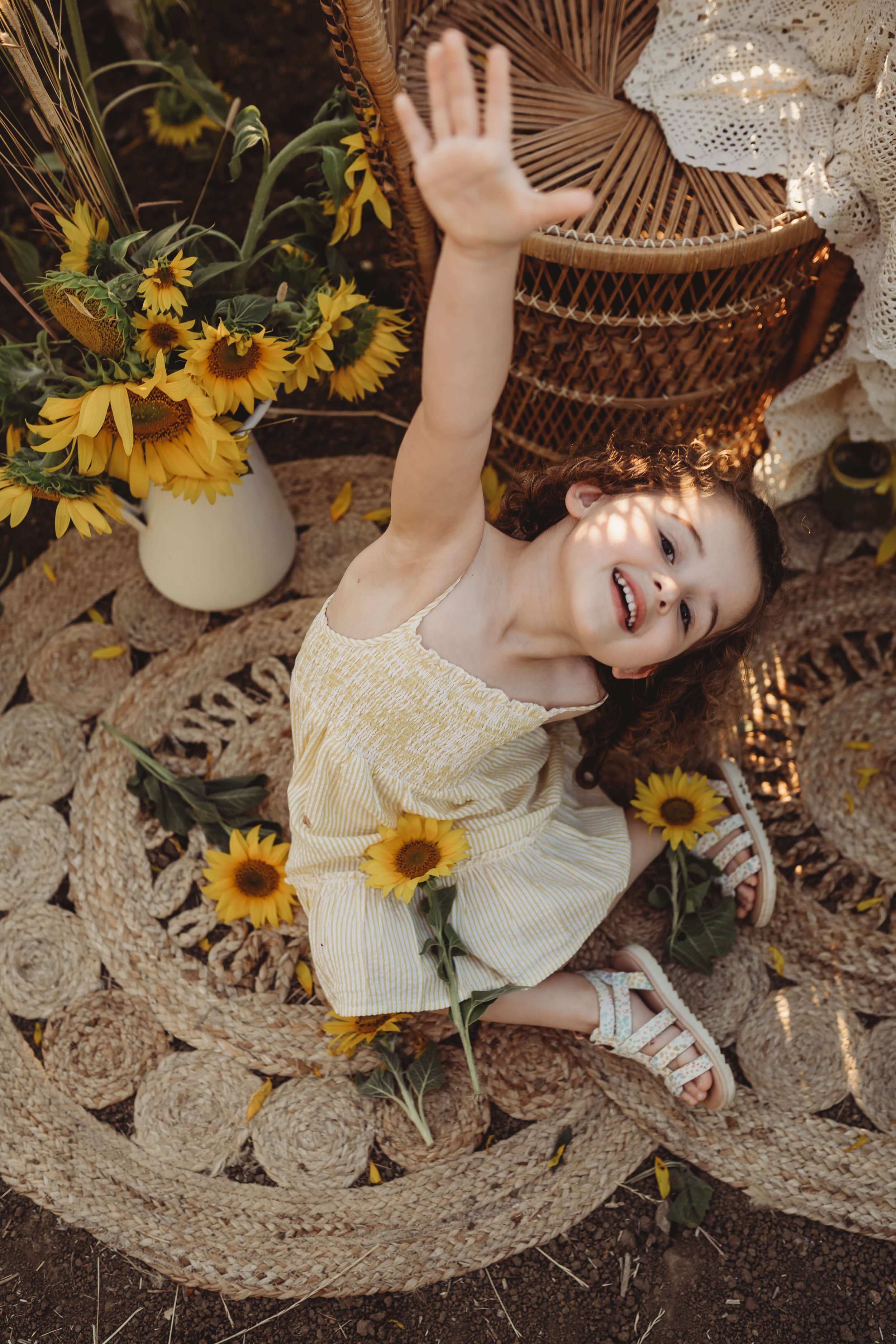 girl in boho shot with sunflowers and peacock chair 