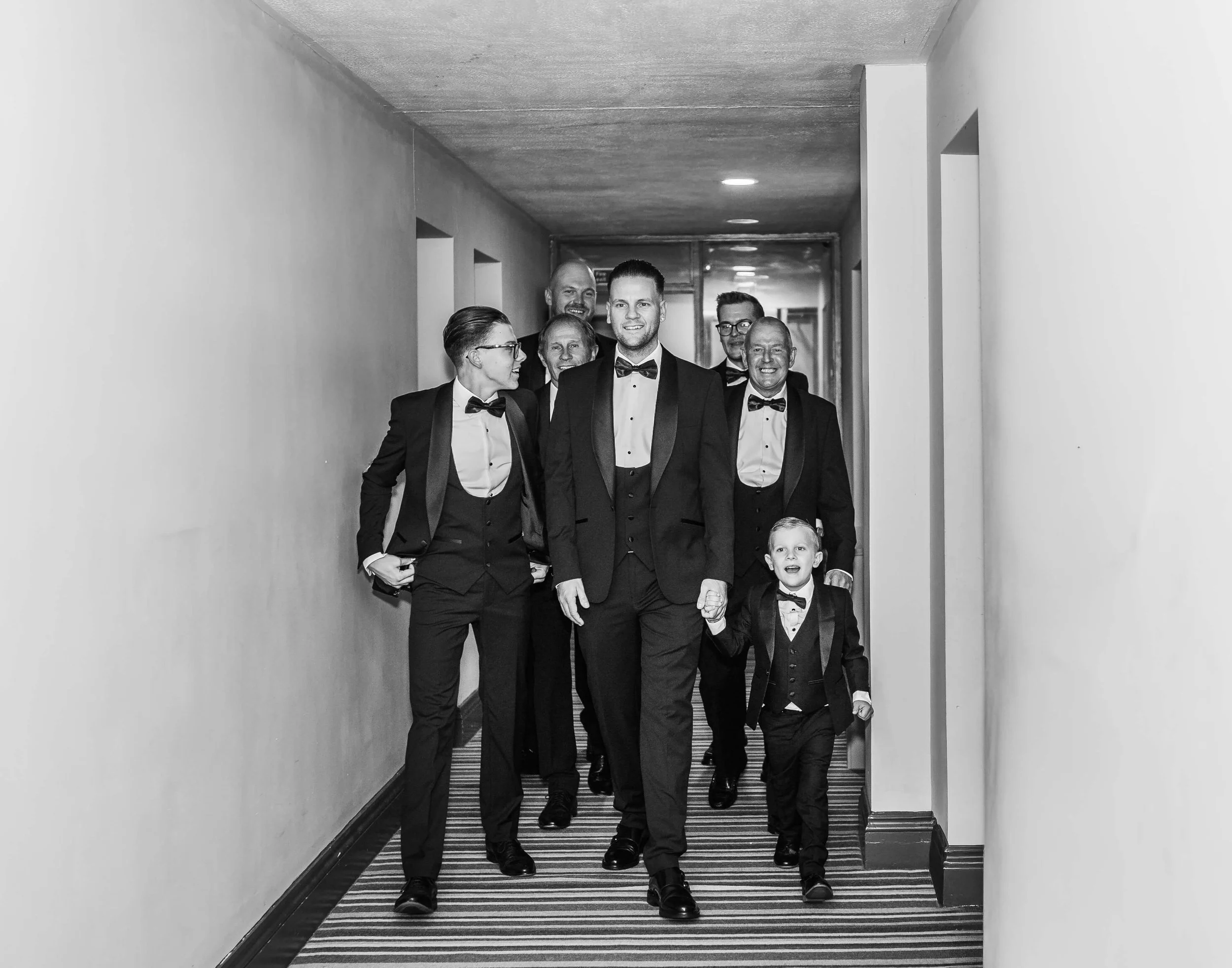 grooms walking down corridor of Rochford hotel Essex