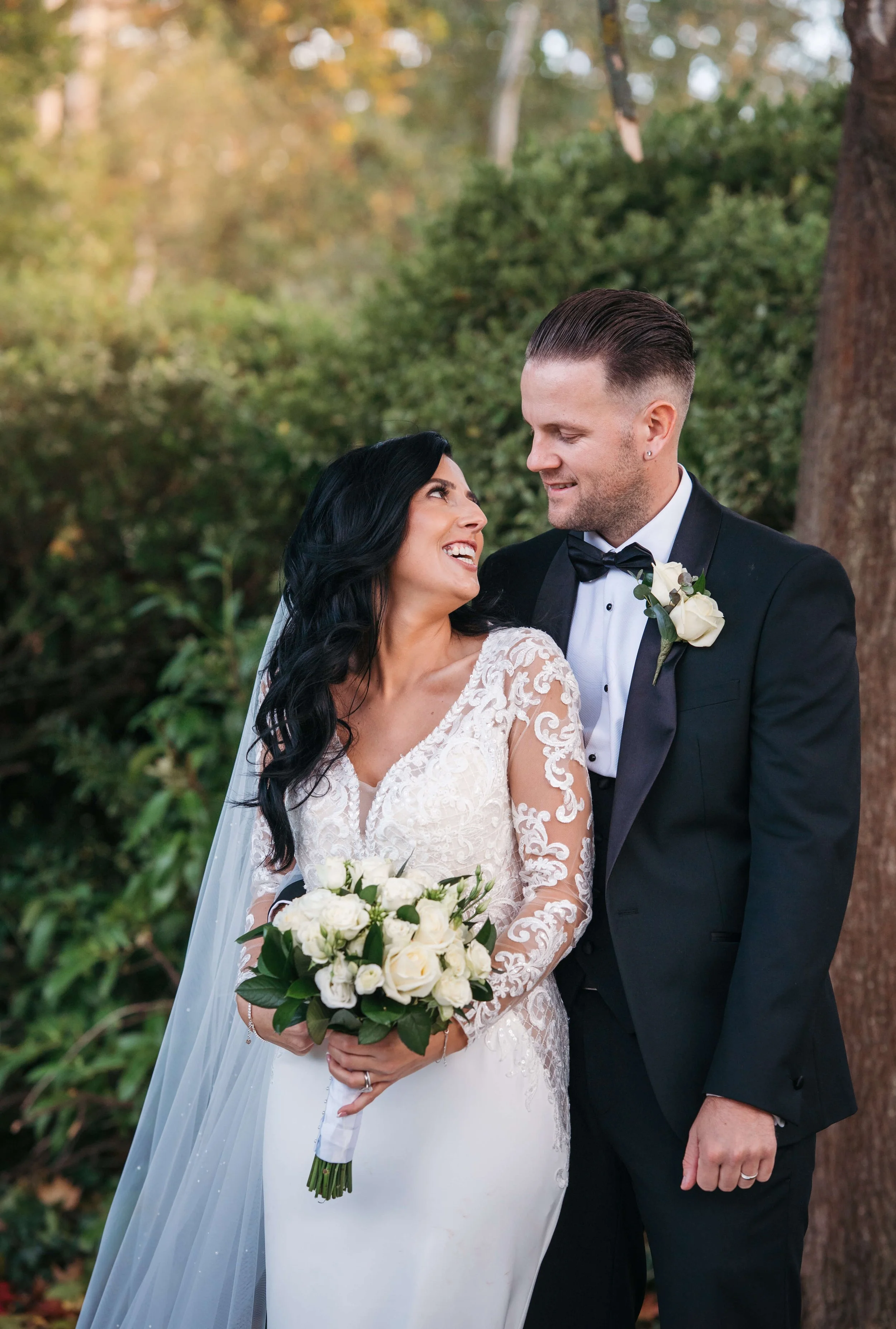 bride and groom portrait photos posing in the garden staring into each others eyes 
