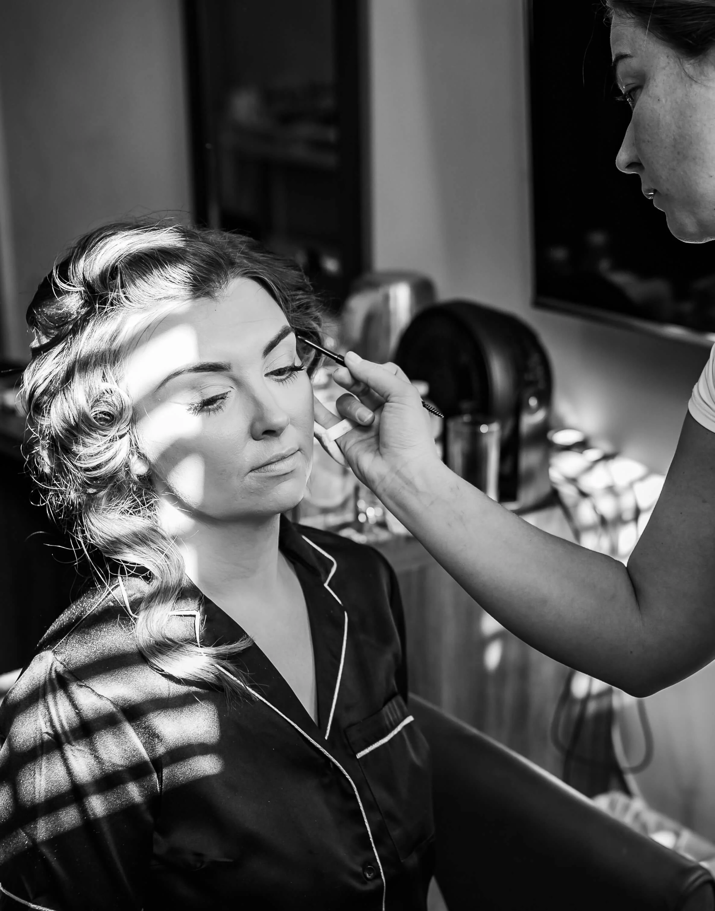 Bridesmaid getting professional make up applied before wedding
