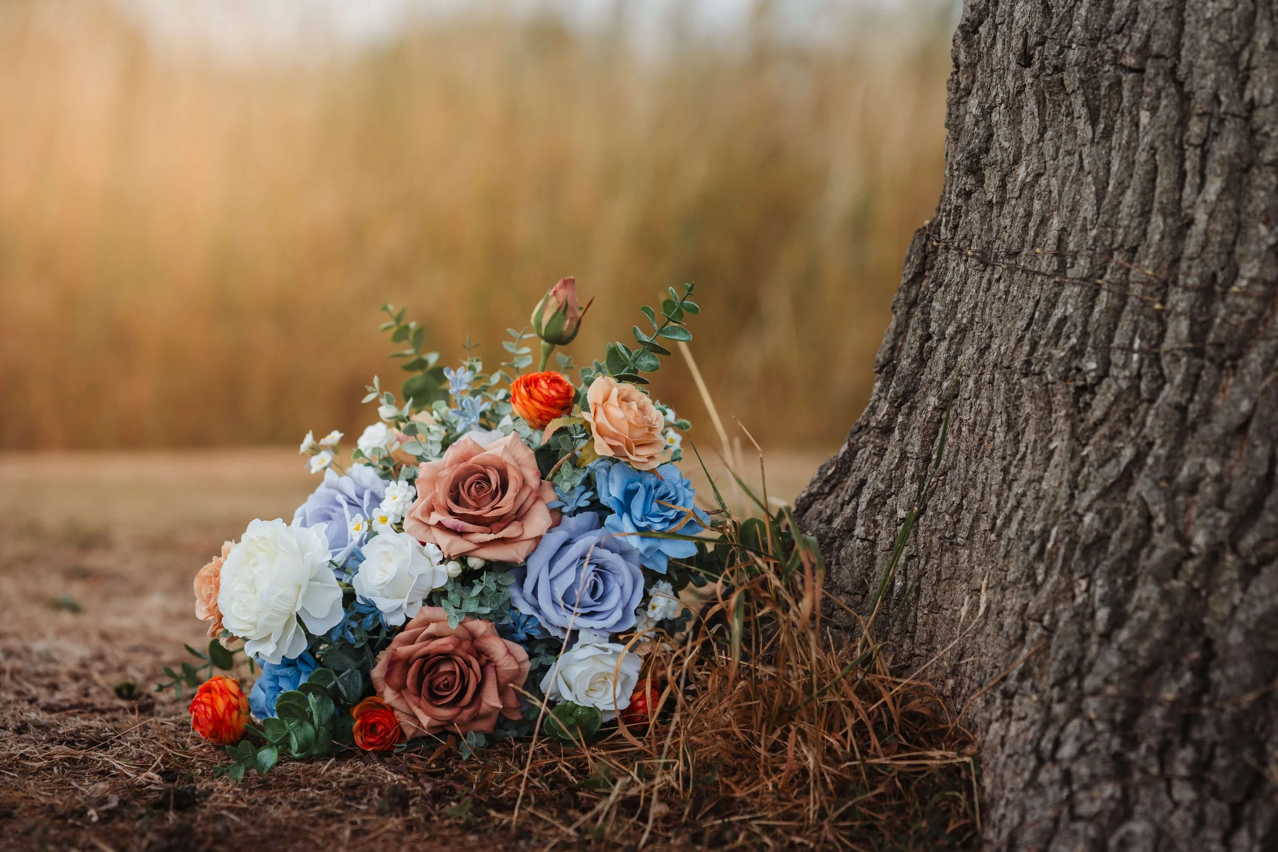 brides bouquet rested at the foot of a tree 