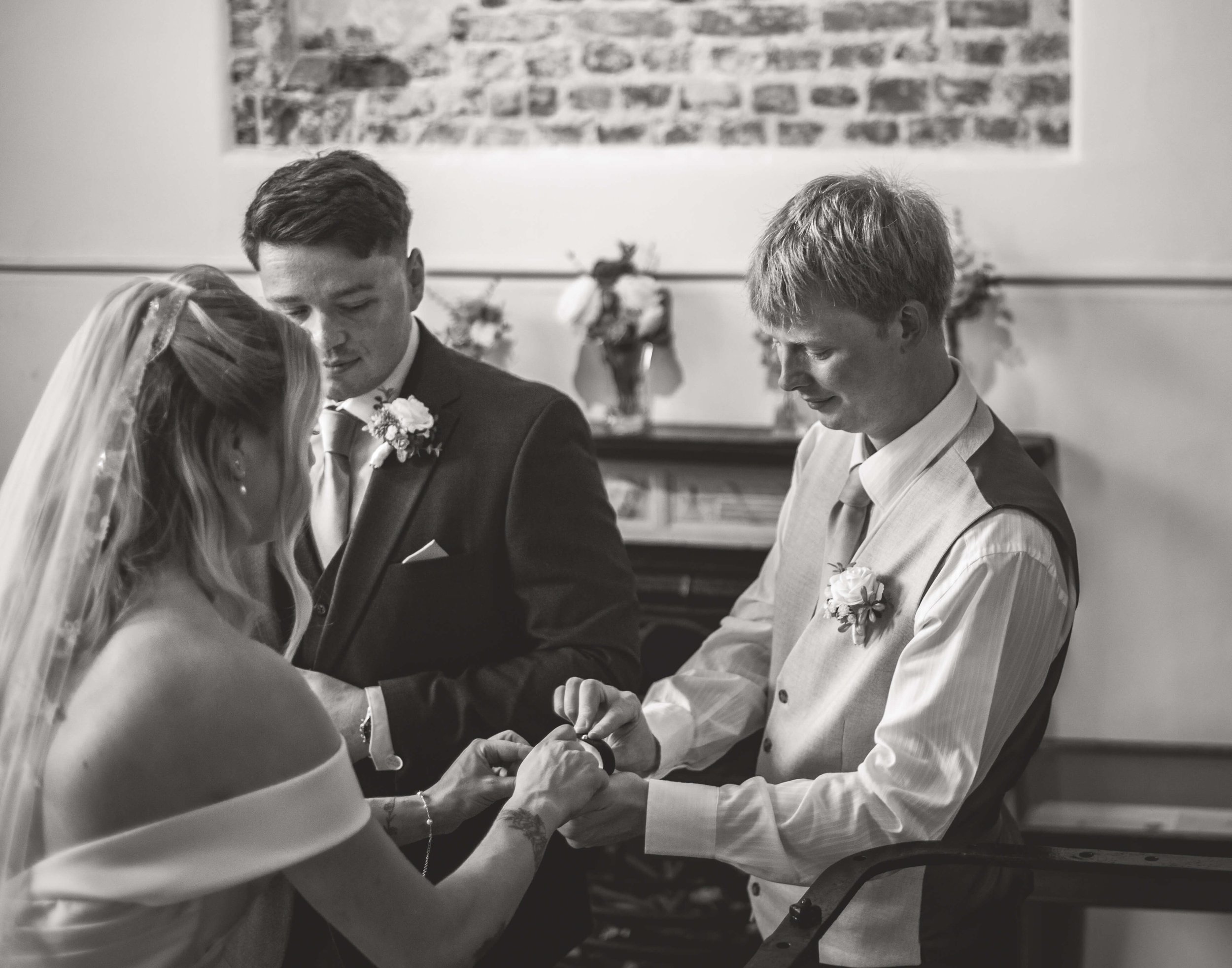 brides brother handing her the marital rings