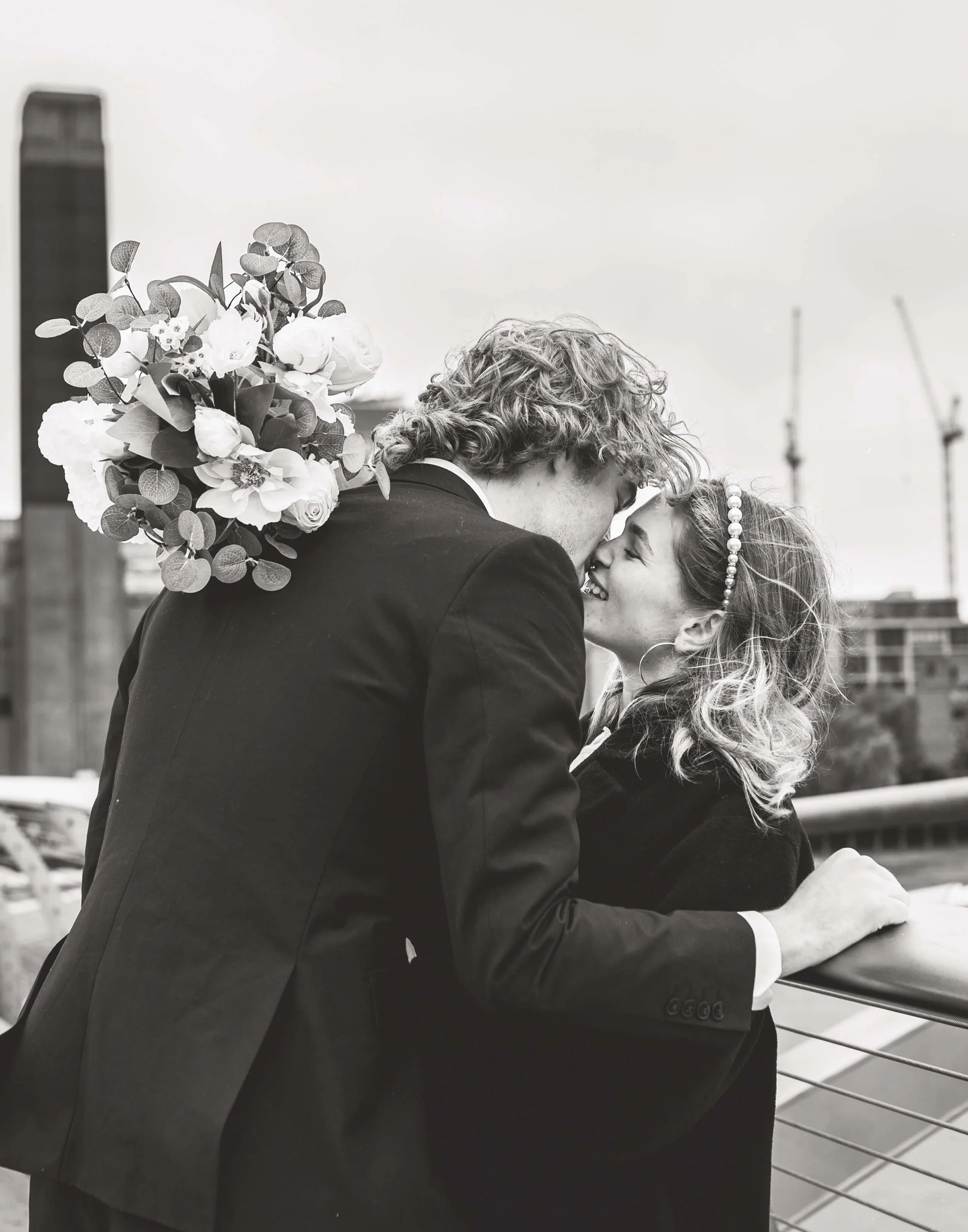 bride and groom kiss on millennium bridge in London