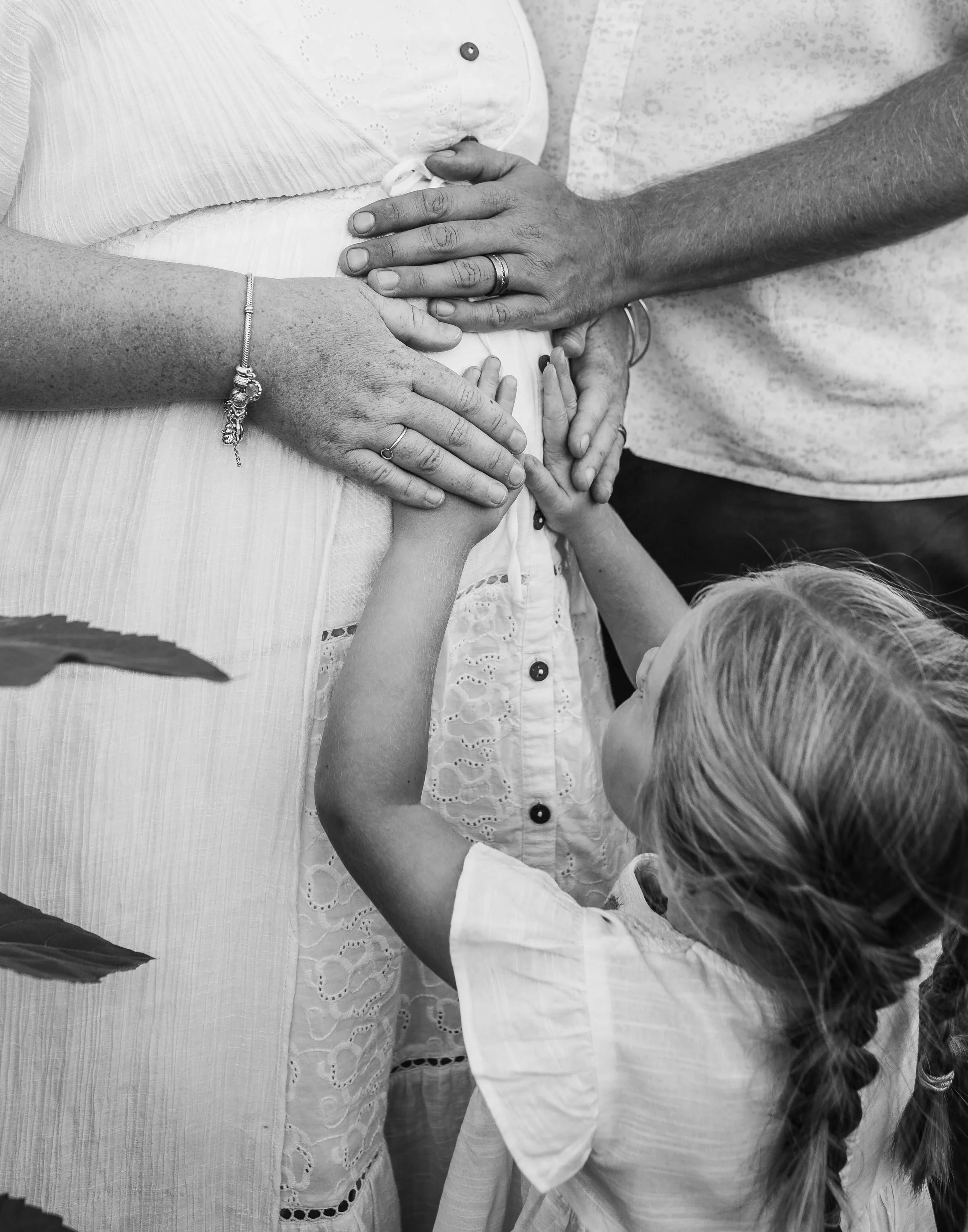 hands gently touching mums pregnant belly 