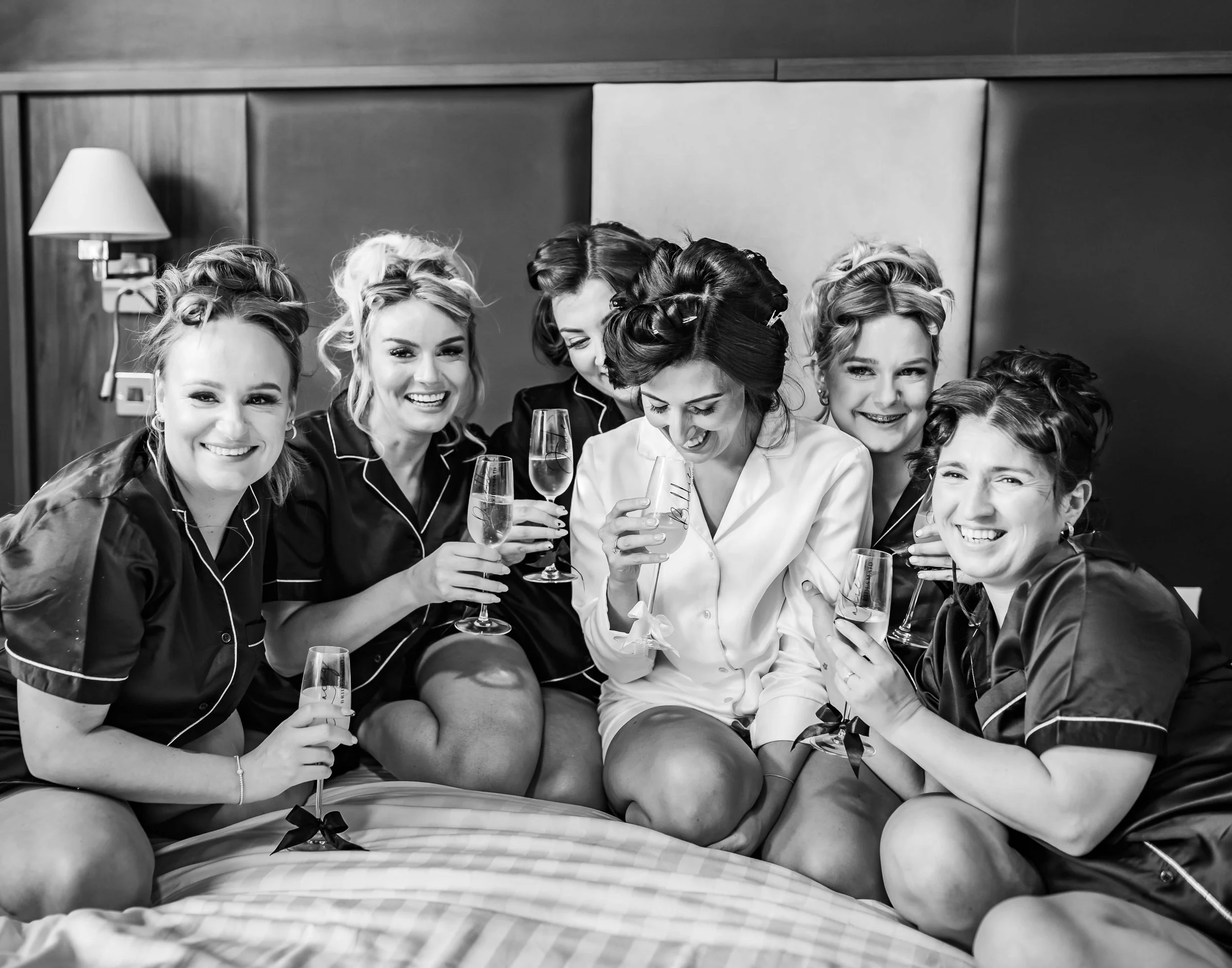 bridal party laughing and drinking together 