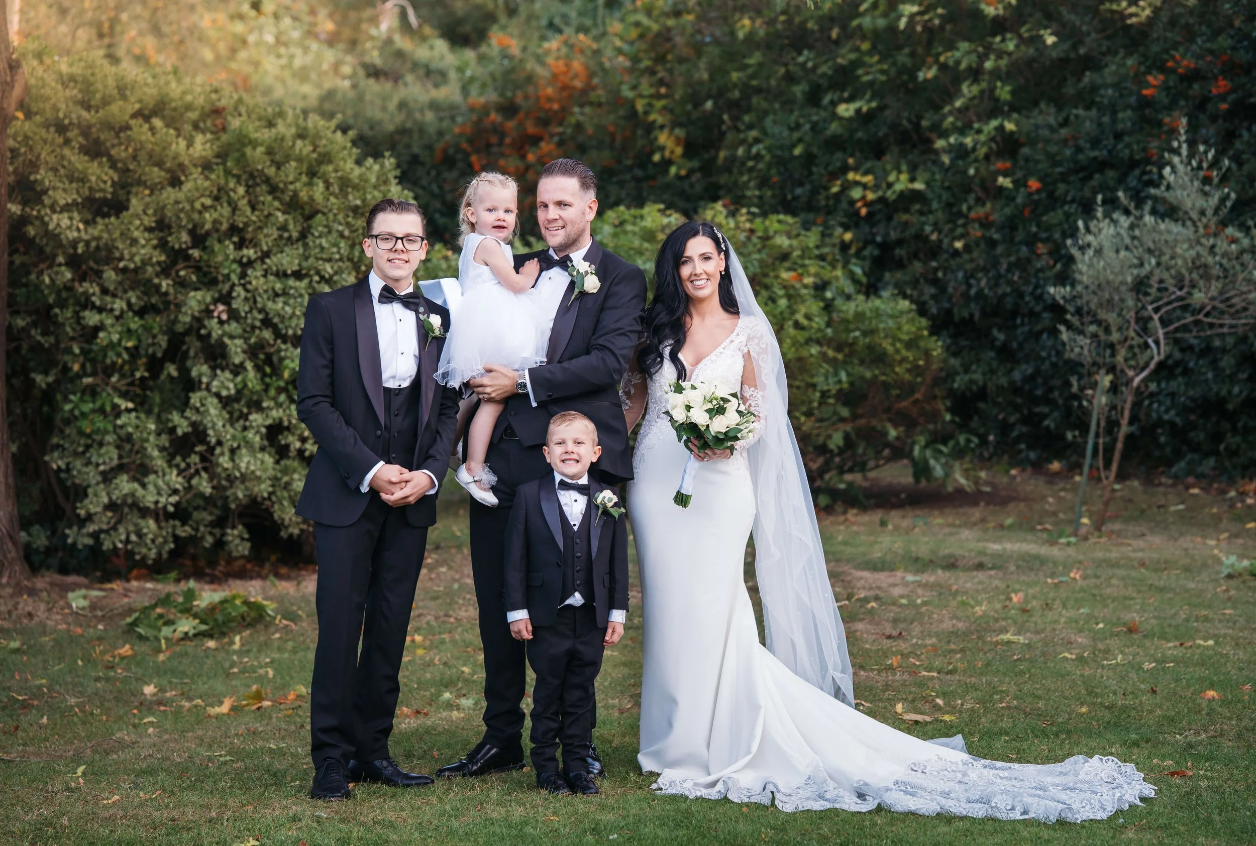 bride and groom and their children portrait in autumnal colours 