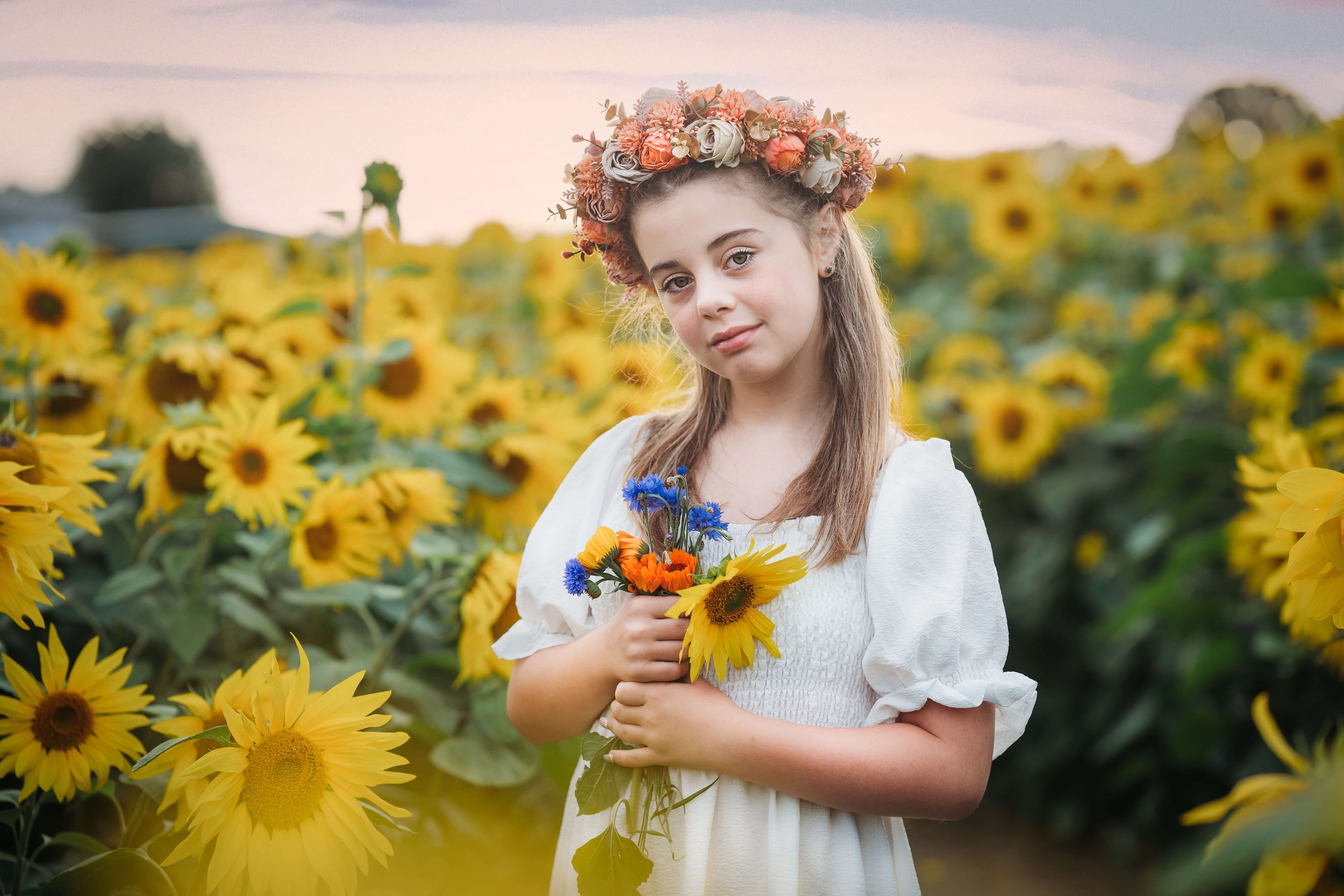 girl in sunflower field with bunch or wildflower photo 