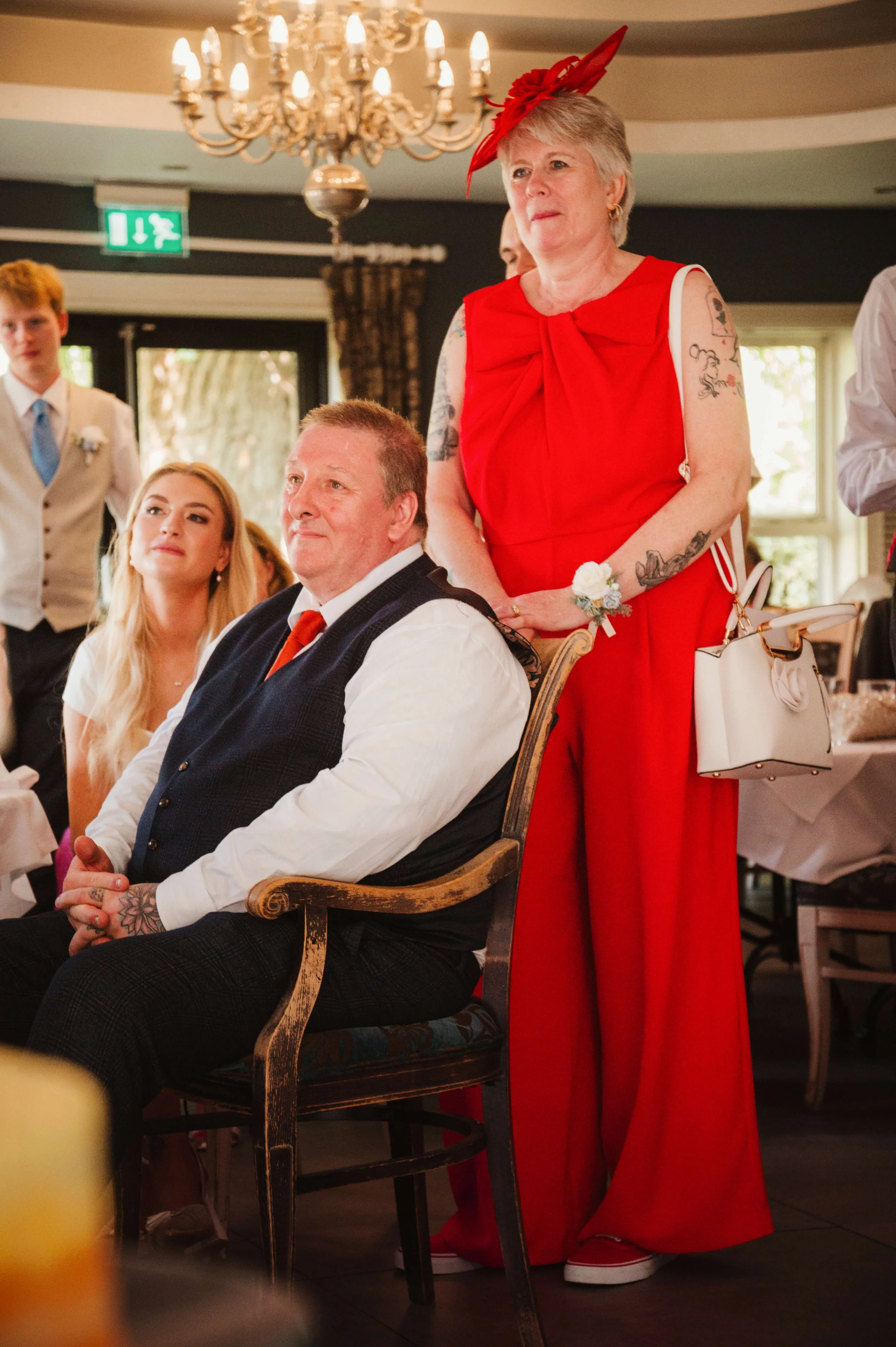 bride and brides parents watch on lovingly as groom delivers his speech