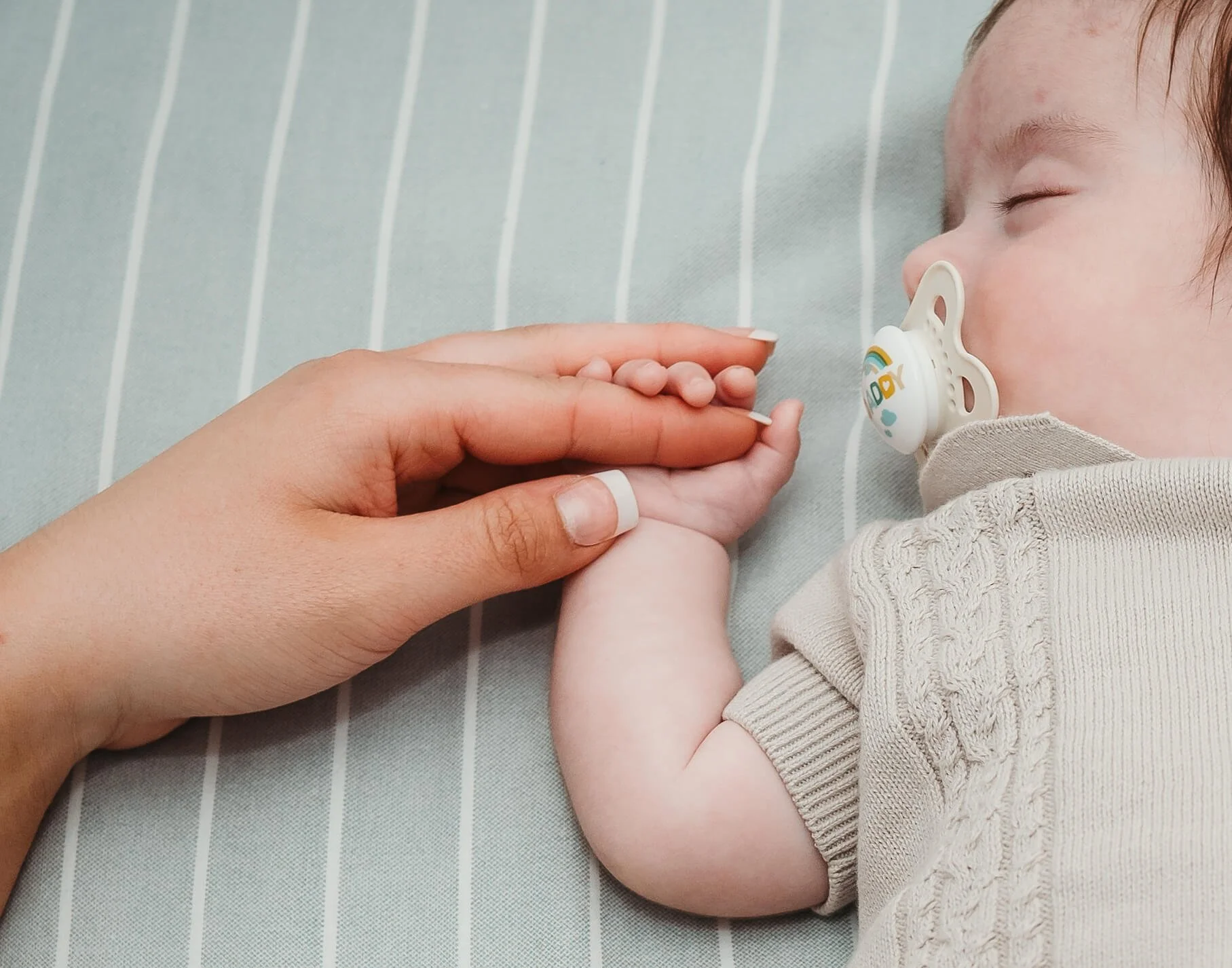 mum holding babies hand 