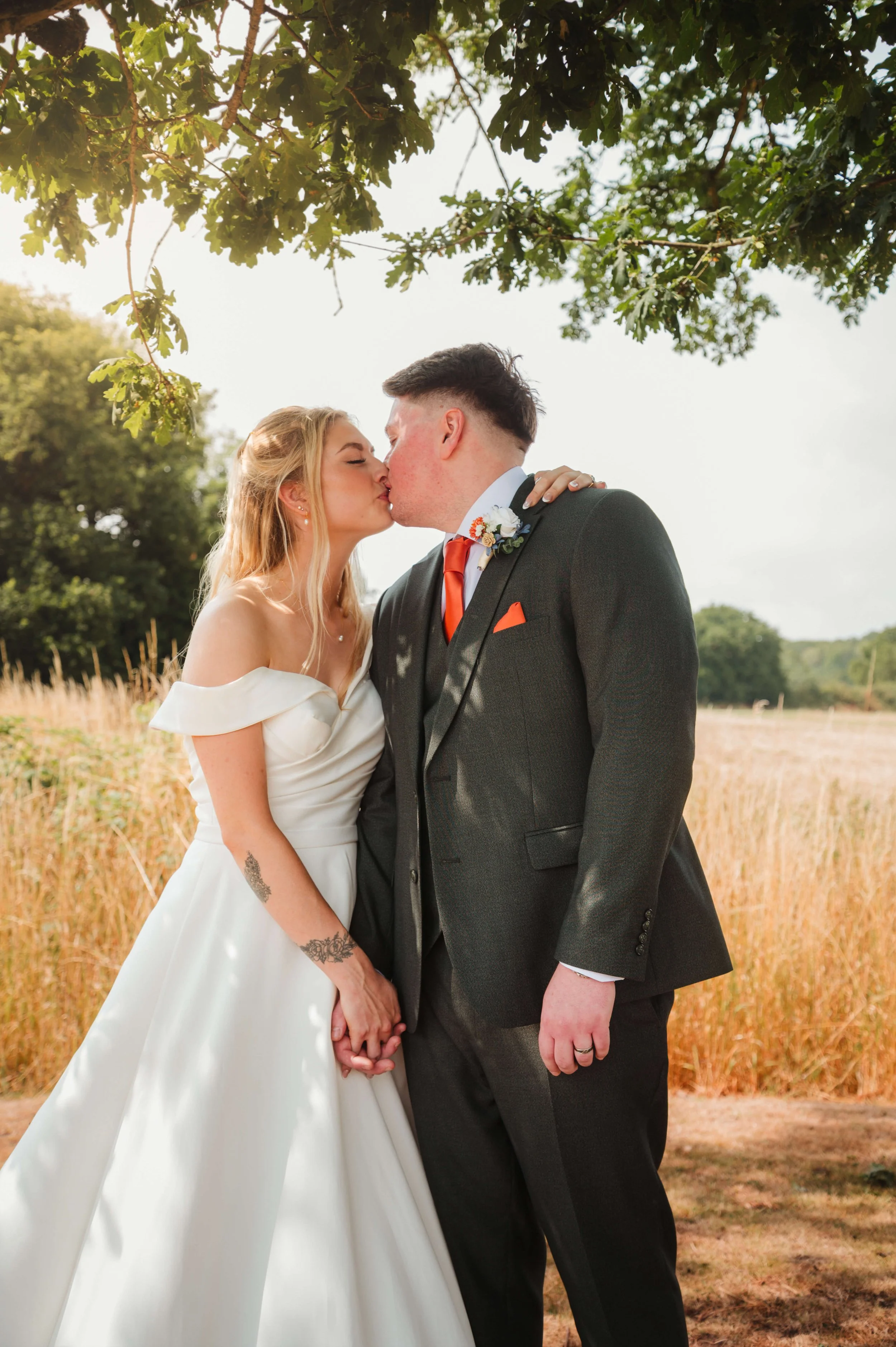 bride and groom sharing a kiss lit u by the golden tones of the sun