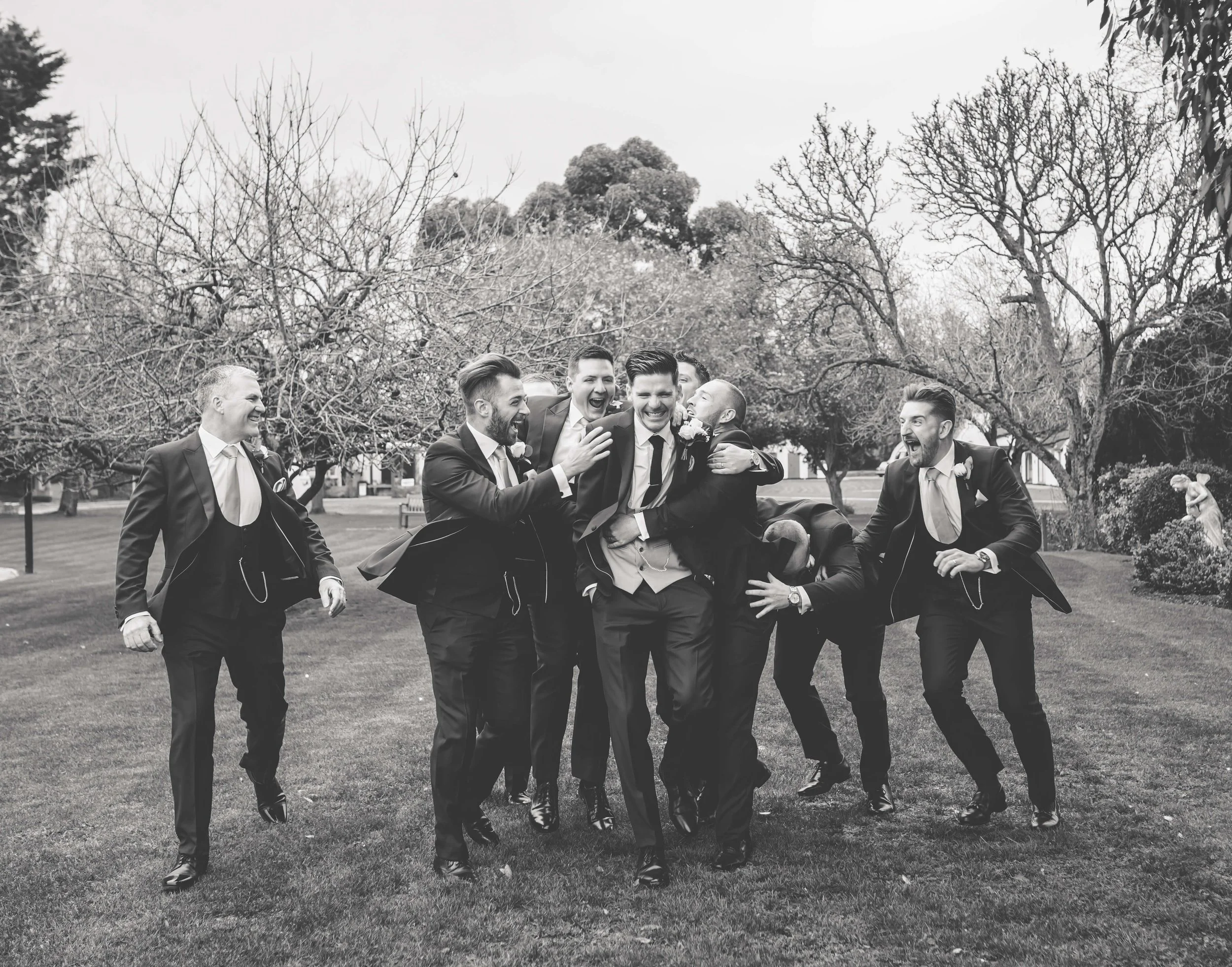 groomsmen laugh and run with groom