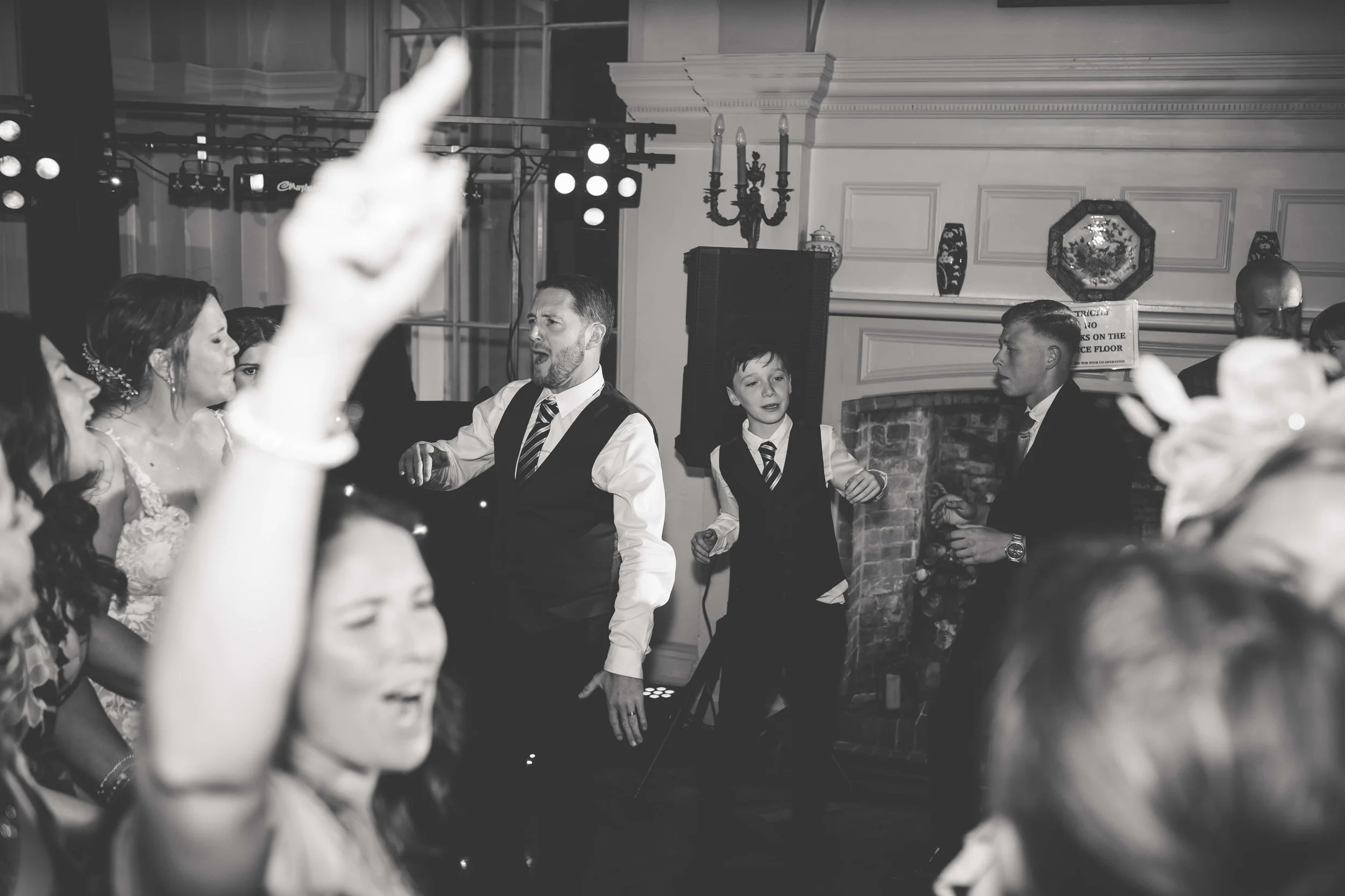 People dancing and socializing at a wedding reception in a decorated indoor venue.
