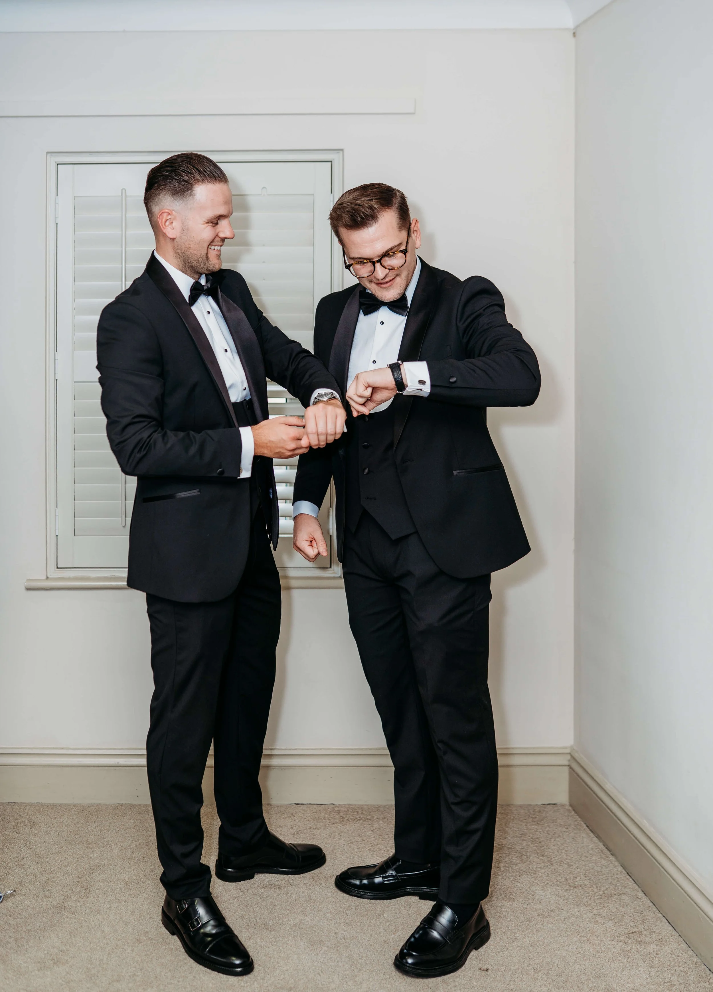 best man and groom looking at watches 